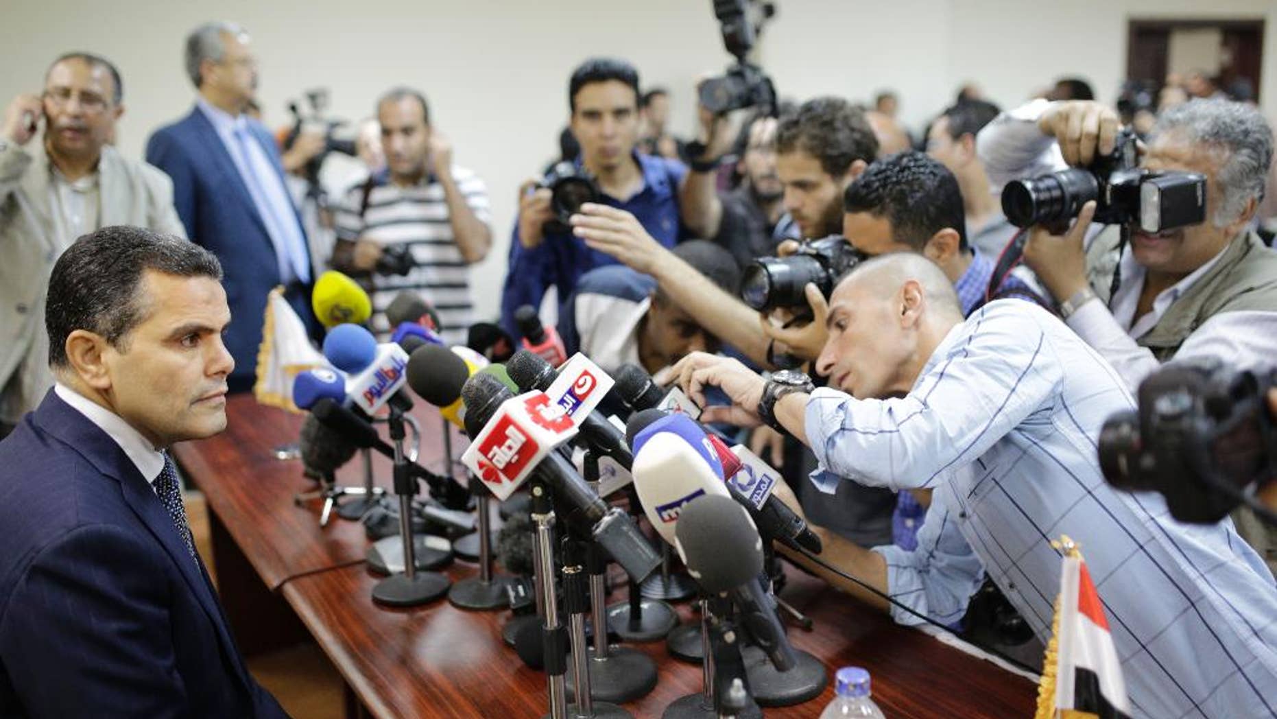 Journalists surround Egypt's Deputy Public Prosecutor Mustafa Suleiman, who headed an Egyptian delegation that was in Rome last week, as he prepares to speak during a press conference on slain Italian graduate student Giulio Regeni, at the prosecutor general's office, in Cairo, Egypt, Saturday, April 9, 2016. (AP Photo/Amr Nabil)