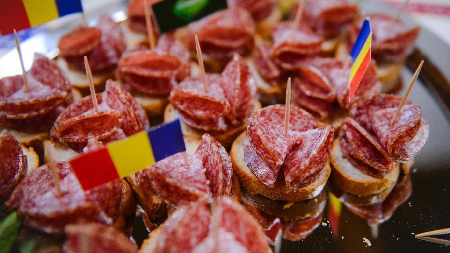 FILE- In this Friday, March. 18, 2016 file picture a platter of Sibiu salami, the local king of the smoked sausages, is presented to the media during a press conference, in Bucharest, Romania. Romanian lawmakers have adopted, Wednesday, June 8, 2016, legislation obliging supermarkets to sell at least 51 percent home-produced meat, fruit, eggs and vegetables in a move to support farmers.(AP Photo/Andreea Alexandru, File) ROMANIA OUT