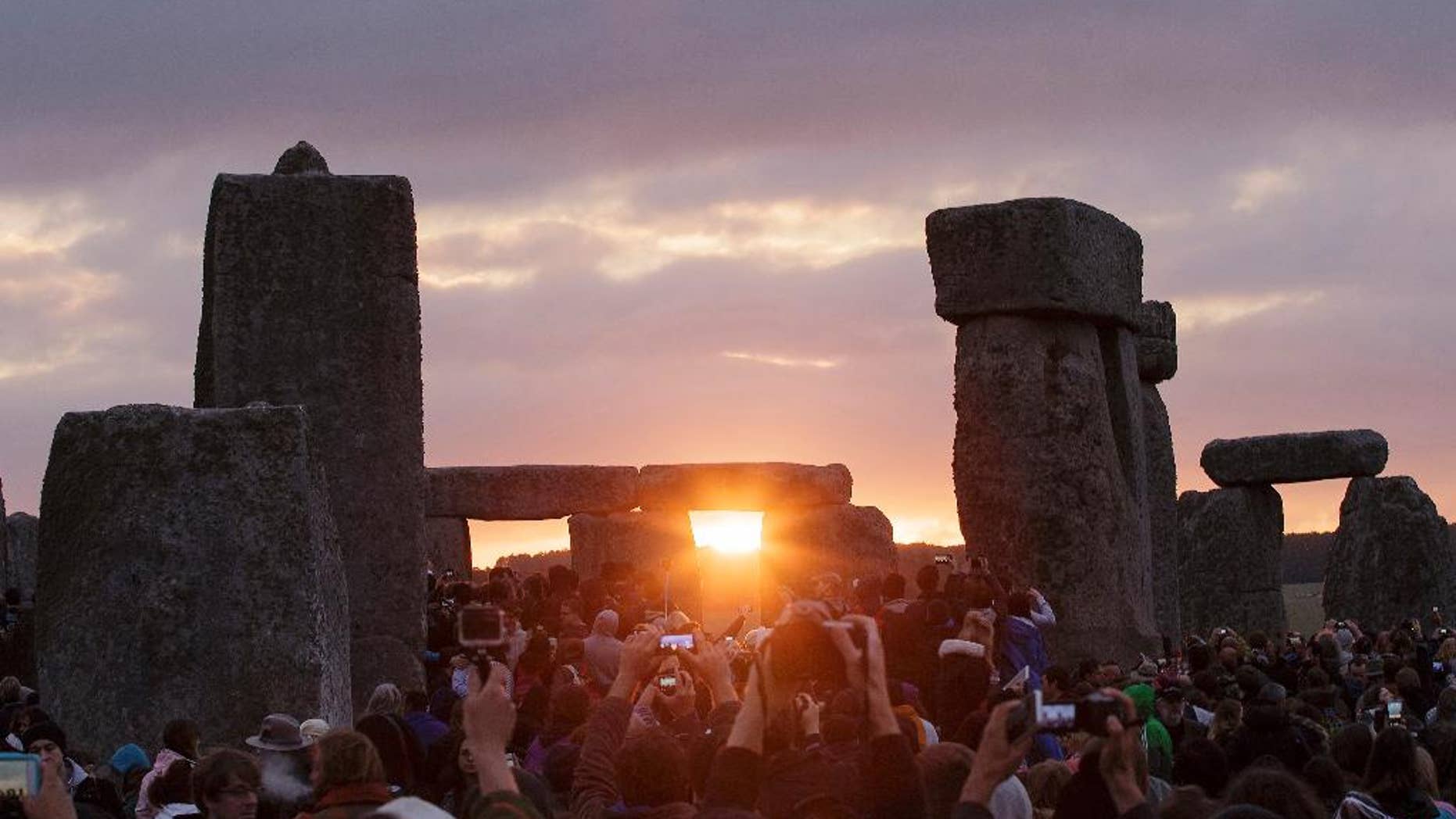 FILE - In this June 21, 2015, file photo, the sun rises as thousands of revelers gathered at the ancient stone circle Stonehenge to celebrate the Summer Solstice, the longest day of the year, near Salisbury, England. The solstice occurs Monday, June 21, 2016, at 6:34 p.m. on the U.S. East Coast. (AP Photo/Tim Ireland, File)