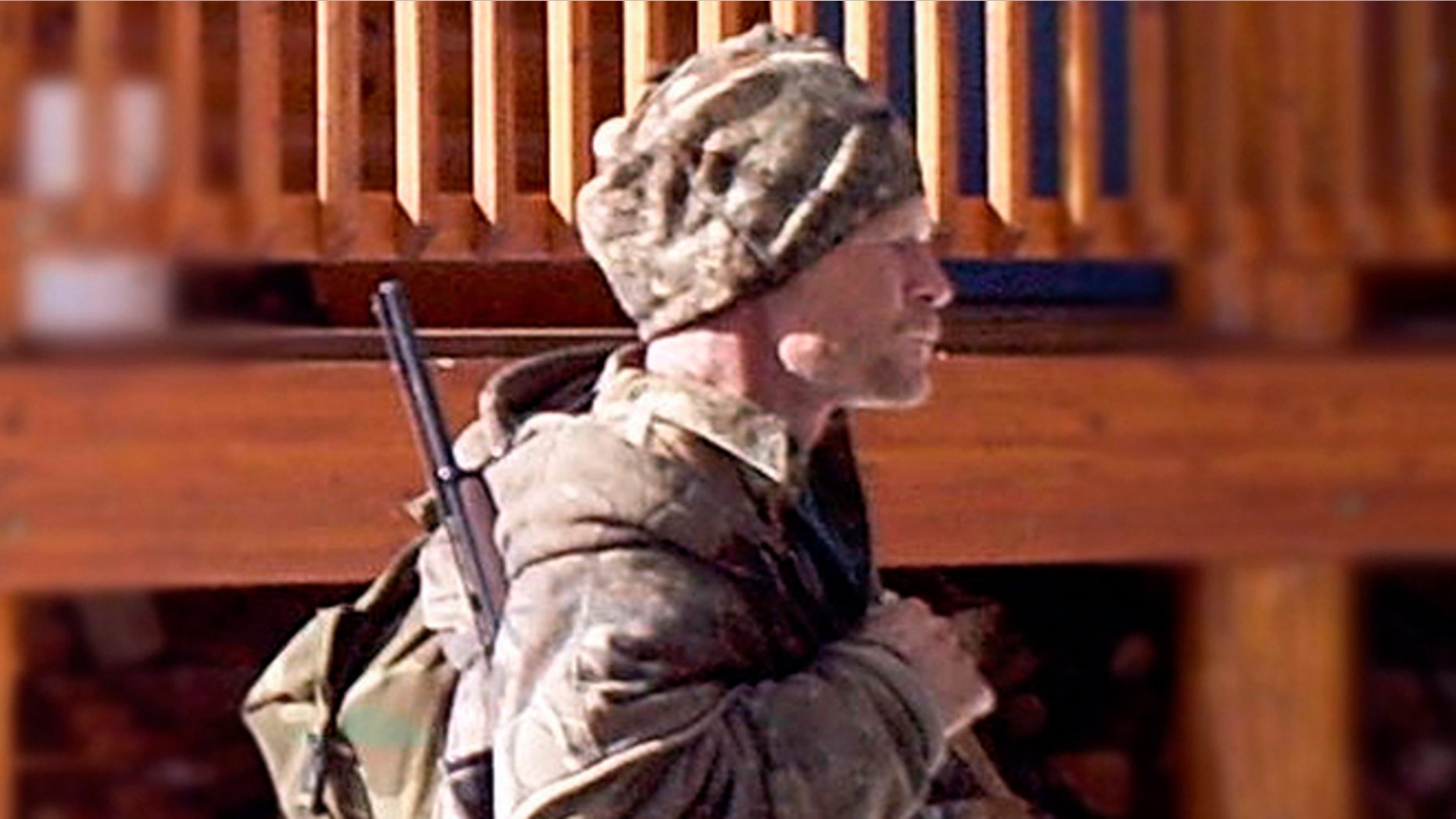 FILE - In this undated file photo provided by the Iron County Sheriff's Office in January 2013, a man identified as Troy James Knapp walks past a cabin in the remote southern Utah wildness near Zion National Park. Authorities say they have arrested Knapp, a survivalist suspected of burglarizing Utah cabins and evading law enforcement for years.