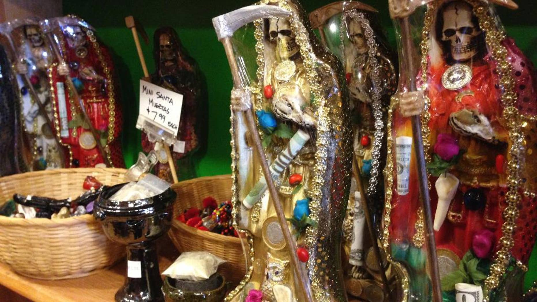 FILE - In this Feb. 13, 2013, file photo, statues of La Santa Muerte are displayed at the Masks y Mas art store in Albuquerque, N.M. Bishops in the United States are finally denouncing the skeleton folk saint known as La Santa Muerte, a figure often connected to the illicit drug trade in Mexico. (AP Photo/Russell Contreras, File)