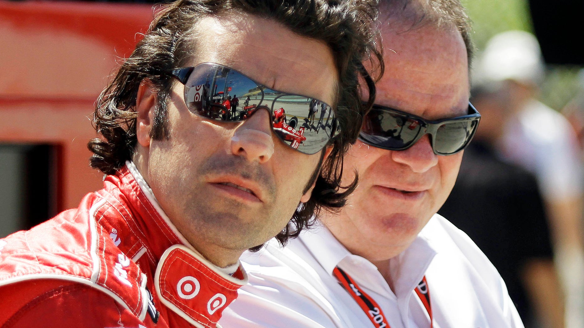 FILE - In this Oct. 1, 2010, file photo, IndyCar driver Dario Franchitti, left and team owner Chip Ganassi talk before practice for the IRL Indy 300 auto race at Homestead-Miami Speedway in Homestead, Fla. When Franchitti made a rare call from Scotland to his boss, Chip Ganassi knew immediately something was wrong. He could hear the heartbreak over the line. Franchitti then delivered the news: Doctors had told him it was time to quit. (AP Photo/Terry Renna, File)