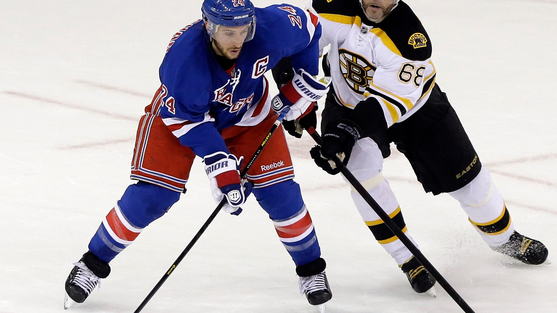 Boston Bruins' Jaromir Jagr (68) and Ryan Callahan (24) fight for control of the puck during the first period in Game 4 of the Eastern Conference semifinals in the NHL hockey Stanley Cup playoffs on Thursday, May 23, 2013, in New York. (AP Photo/Frank Franklin II)