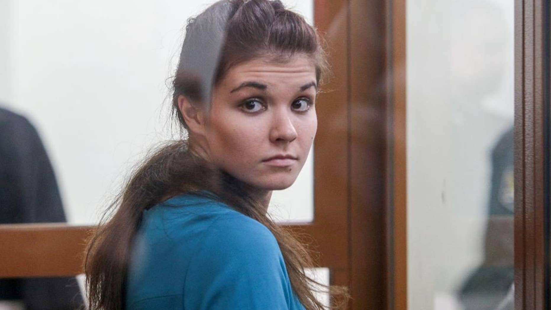 Varvara Karaulova, who was detained last year in Turkey as she was reportedly trying to cross the border into Syria, sits in a cage in the Moscow District Military Court in Moscow, Russia, Thursday, Dec. 22, 2016. A Moscow court has sentenced a 20-year old university student to four and a half years in prison for trying to join Islamic State group fighters in Syria. (Andrey Nikerichev/Moscow news agency via AP)