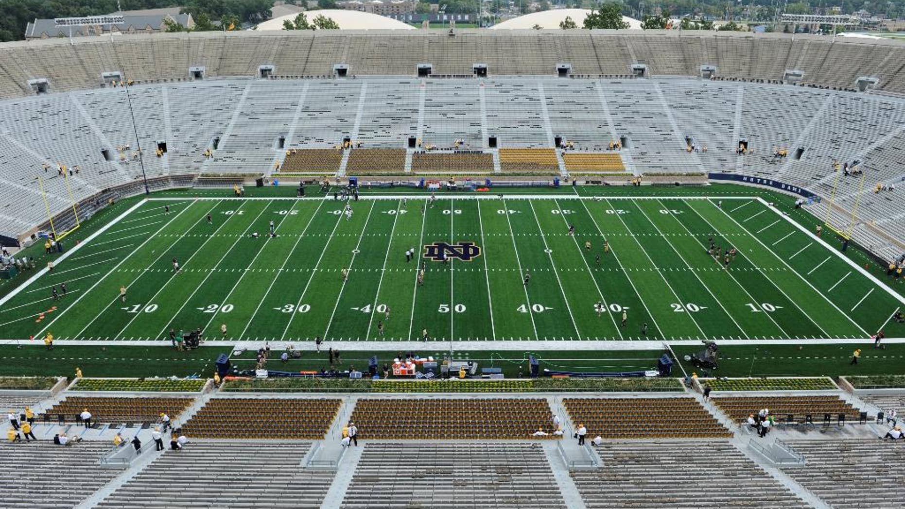 Players loosen up on the new artificial field before an NCAA college football game between Notre Dame and Rice in South Bend, Ind. Saturday Aug. 30, 2014. (AP Photo/Joe Raymond)