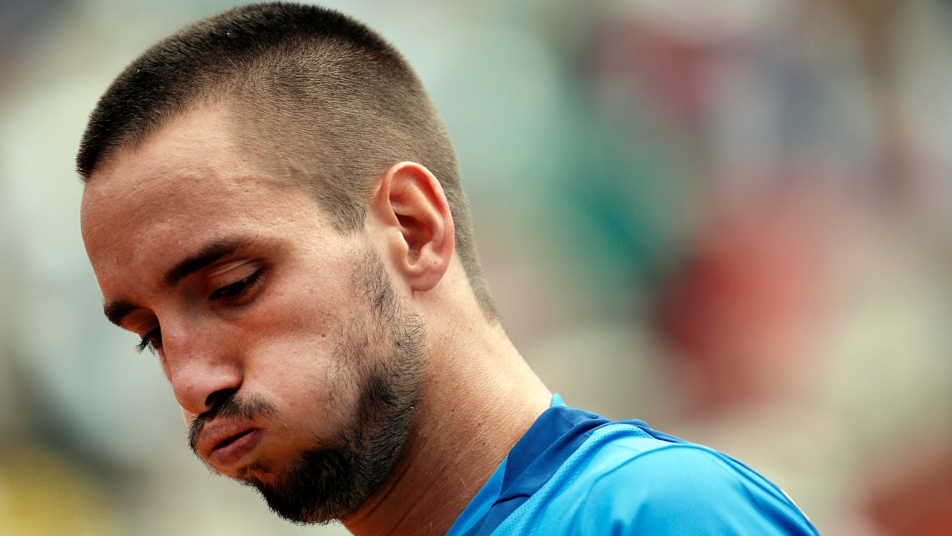 FILE - In this June 2, 2013, file photo, Serbia's Viktor Troicki blows out air as he plays France's Jo-Wilfried Tsonga during their fourth round match of the French Open tennis tournament at the Roland Garros stadium in Paris. Troicki’s doping ban was reduced from 18 months to 12 on Tuesday, Nov. 5, 2013 although he still cannot play in next week's Davis Cup final. (AP Photo/Christophe Ena, File)