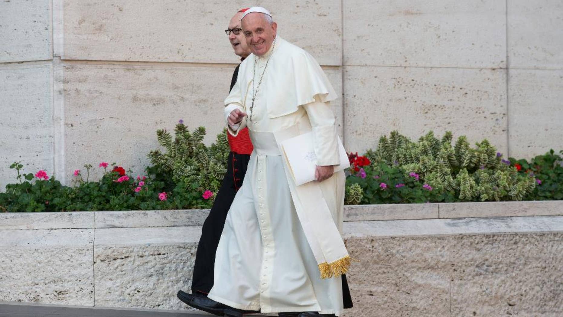 Pope Francis, flanked by Cardinal Fernando Sebastian Aguilar, arrives at a morning session of a two-week synod on family issues at the Vatican, Tuesday, Oct. 7, 2014. Francis has urged bishops to speak their minds about contentious issues like contraception, gays, marriage and divorce at the start of the meeting aimed at making the church's teaching on family matters relevant to today's Catholics. (AP Photo/Alessandra Tarantino)