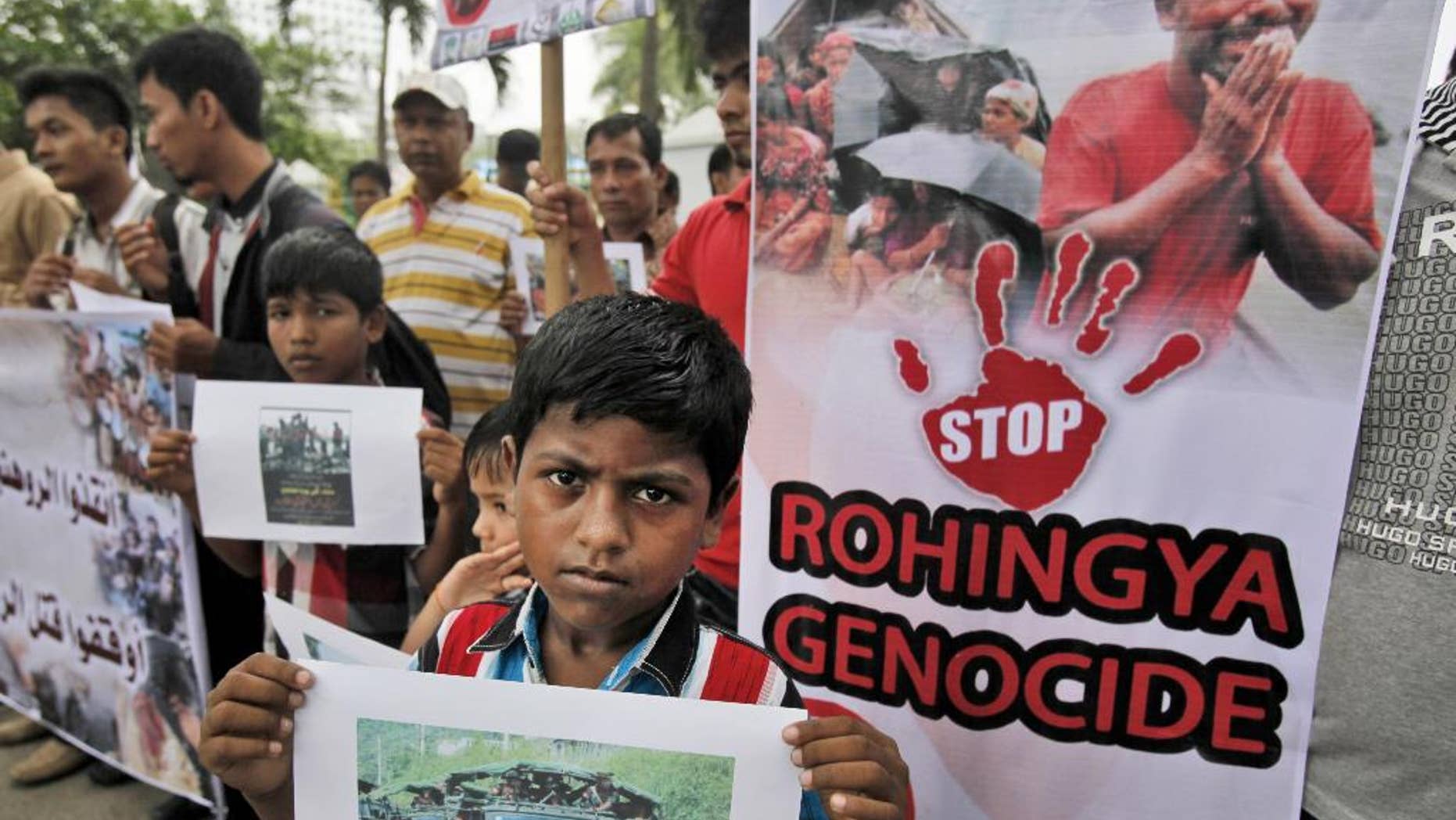 Ethnic Rohingya migrants hold banners during a rally in Medan, North Sumatra, Indonesia, Tuesday, May 12, 2015. Hundreds of migrants abandoned at sea by smugglers in Southeast Asia have reached land and relative safety in the past two days. But an estimated 6,000 Bangladeshis and Rohingya Muslims from Myanmar remain trapped in crowded, wooden boats, migrant officials and activists said. With food and clean water running low, some could be in grave danger. (AP Photo/Binsar Bakkara)