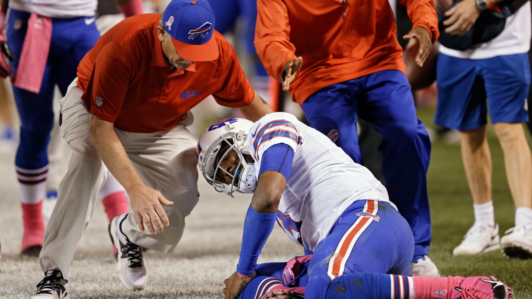 A trainer rushes to help Buffalo Bills quarterback EJ Manuel after he was injured on a third-quarter run against the Cleveland Browns in the third quarter of an NFL football game Thursday, Oct. 3, 2013, in Cleveland. (AP Photo/Tony Dejak)