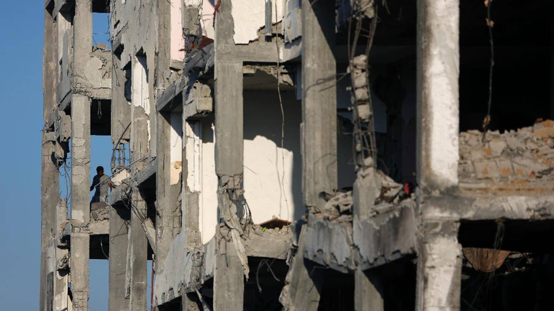 A Palestinian man inspects the damage of his flat in the destroyed Nada Towers residential neighborhood in the town of Beit Lahiya, northern Gaza Strip, Monday, Aug. 11, 2014. A new temporary truce took hold, Monday, in the monthlong war pitting the Israeli military against rocket-firing Hamas militants as negotiators from Israel and the Hamas militant group resumed indirect talks in Egypt on Monday. (AP Photo/Khalil Hamra)