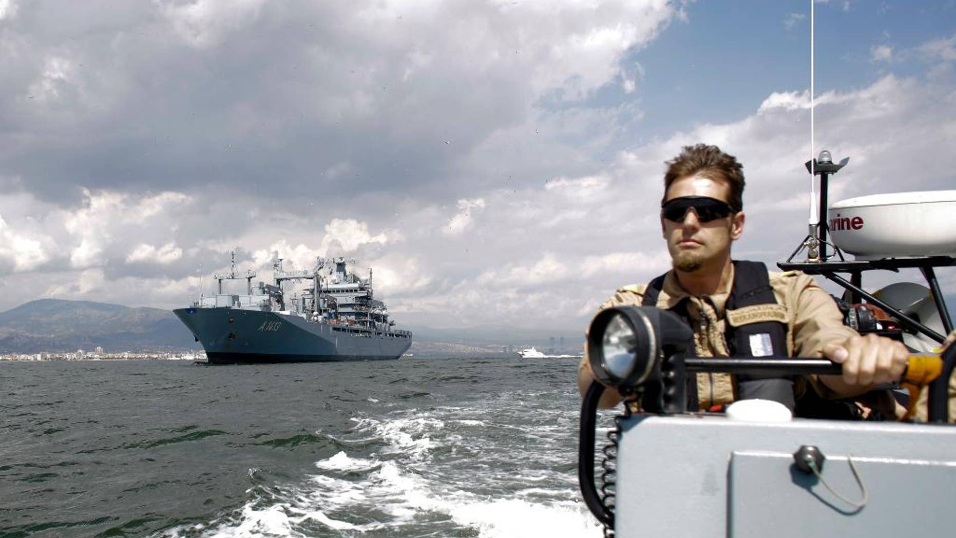 FILE - In this Thursday, May 26, 2016 file photo, The NATO German warship FGS Bonn, left, is escorted by a rescue boat as it departs from the harbor of the city of Izmir, Turkey. The FGS Bonn is part of the NATO flotilla patrolling the Aegean Sea in an effort to curb migrant activity between Turkey and Greece. (AP Photo/Markus Schreiber, File)