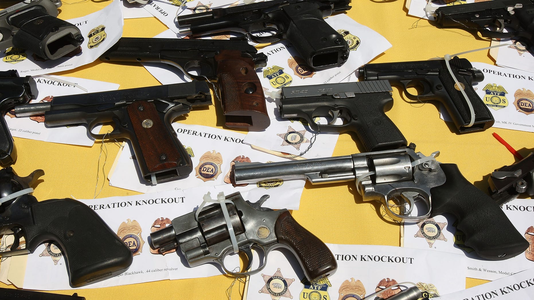 LAKEWOOD, CA - MAY 21: Some of about 125 weapons confiscated during what the federal authorities say is the largest gang takedown in United States history are displayed at a press conference to announce the arrests of scores of alleged gang members and associates on federal racketeering and drug-trafficking charges on May 21, 2009 in the Los Angeles-area community of Lakewood, California. 147 people were indicted in the case involving racially motivated attacks on African-Americans and law enforcement officers. Operation Knockout is the latest of several investigations that found gangs engaged in race-based violence. Two years ago, a Latino gang was charged with waging a violent campaign to drive blacks out of a Los Angeles-area neighborhood that resulted in 20 homicides. Last year, another Latino gang was accused of targeting blacks and killing 14-year-old Cheryl Green, whose death became a community rallying point. In 2006, Avenues gang members Latinos were convicted of assaults and killings of blacks in the 1990s. (Photo by David McNew/Getty Images)