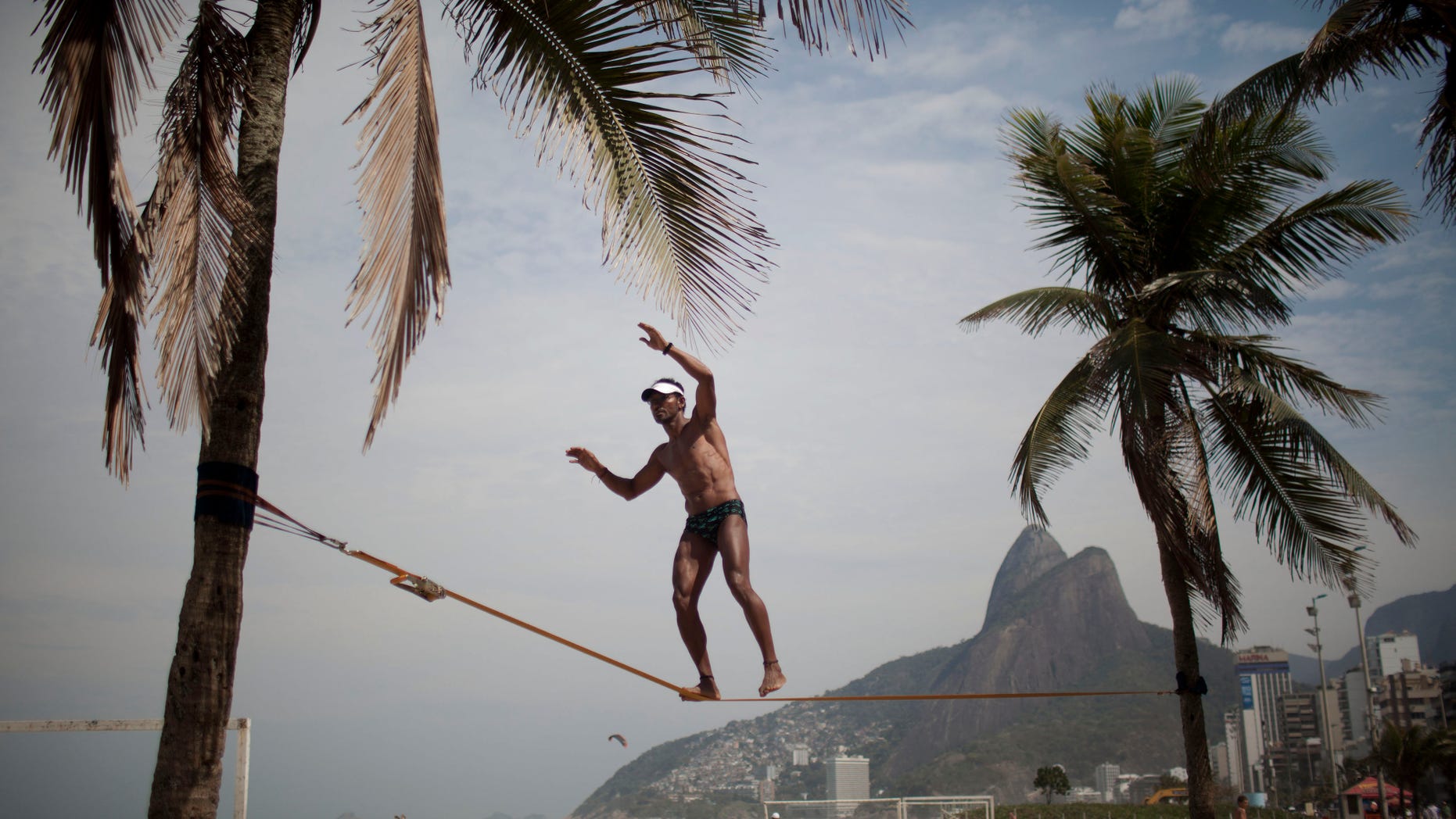 Waltinho da Silva, 48, practices slacklining at Ipanema Beach in Rio de Janeiro, Brazil, Saturday Aug. 20, 2011. (AP Photo/Felipe Dana)