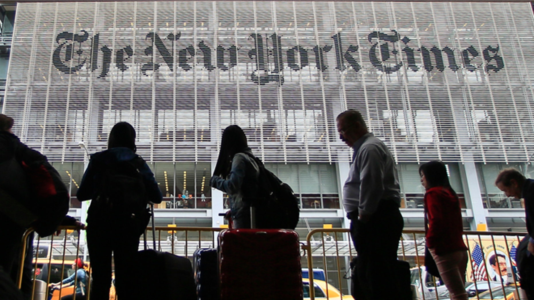 May 14, 2014: Pedestrians wait for cabs across the street from The New York Times in New York. (AP)