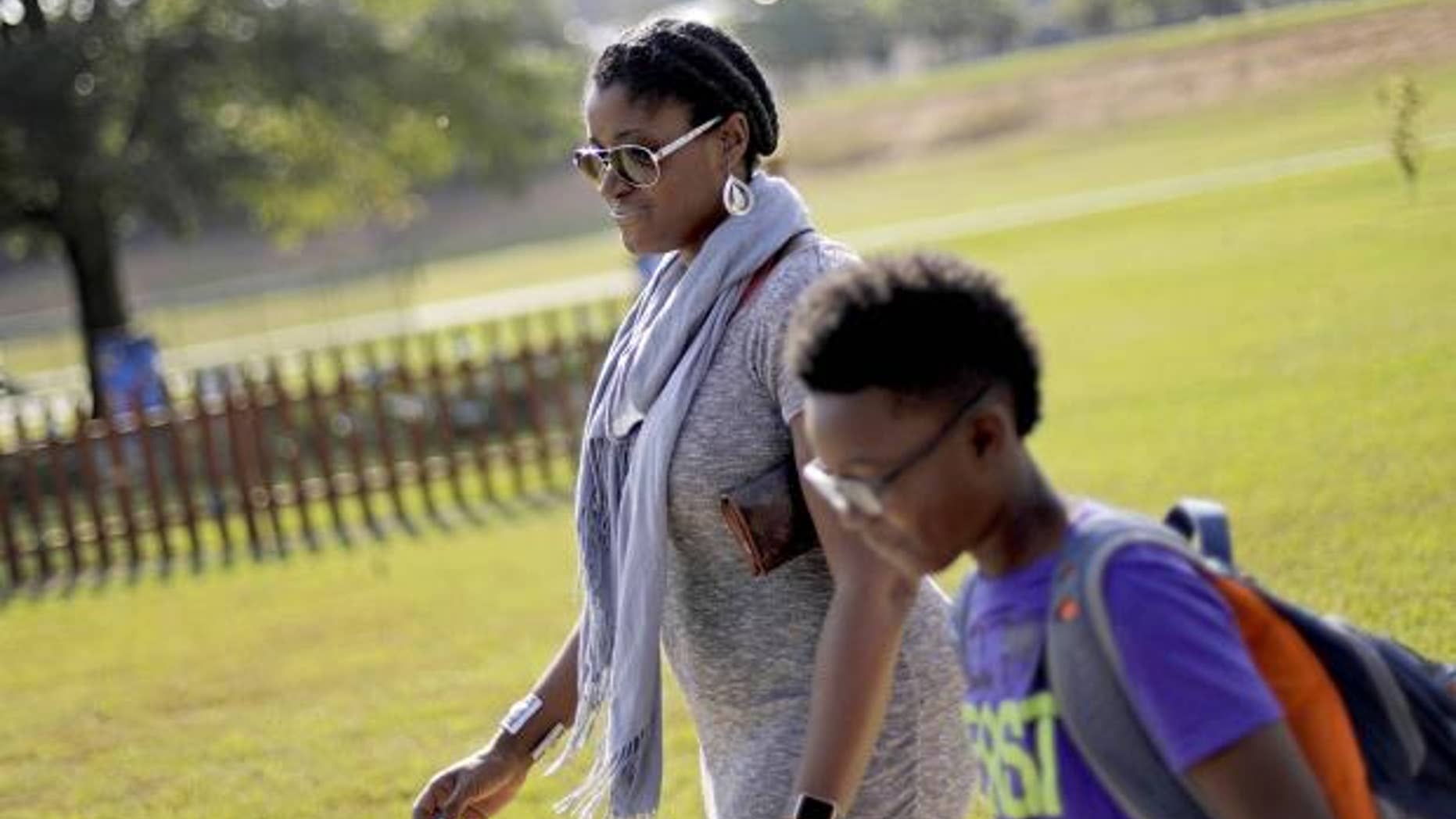Corrie Davis, left, picks up her son Turner from Big Shanty Elementary School in Kennesaw, Ga.