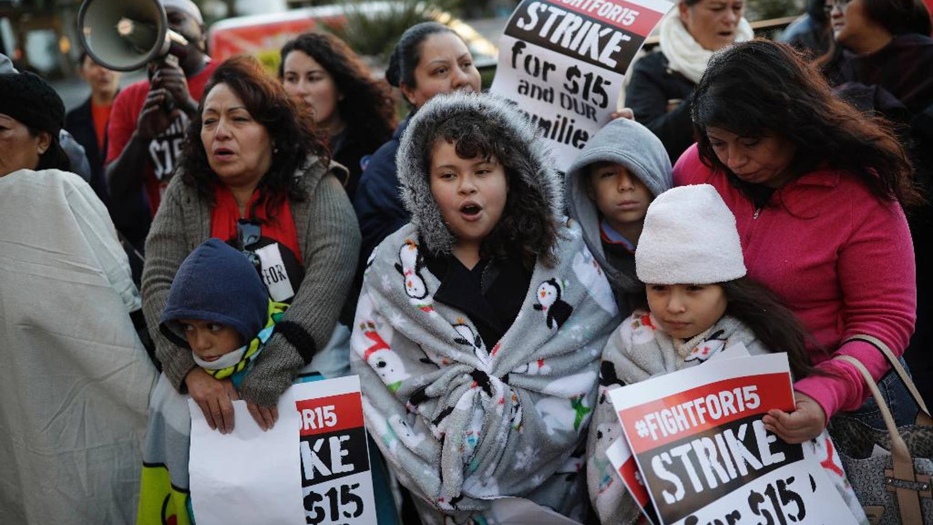 FILE – In this Nov. 29, 2016, file photo, people protest as part of the National Day of Action to Fight for $15 near a McDonald's restaurant along the Las Vegas Strip in Las Vegas. A cluster of Black Lives Matter groups and the organization leading the push for a $15-an-hour wage are joining forces to combine the struggle for racial justice with the fight for economic equality, just as the Rev. Martin Luther King Jr. tried to do in the last year of his life. They are launching their first national joint action on April 4, 2017, the 49th anniversary of King’s assassination, with “Fight Racism, Raise Pay” protests in two dozen cities, including Atlanta; Chicago; Boston; Denver; and Las Vegas. (AP Photo/John Locher, File)