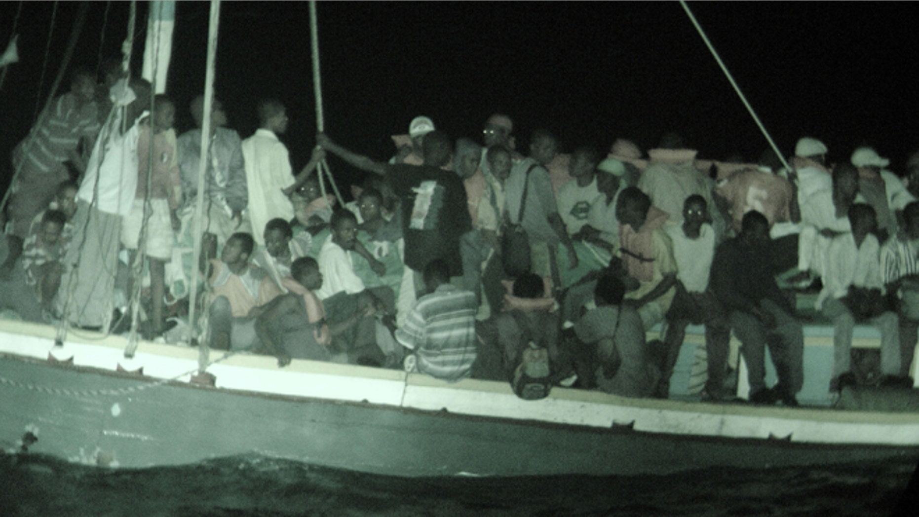 AT SEA - APRIL 30: In this handout photo provided by the U.S. Coast Guard, Haitian migrants wait aboard a 50-foot sailboat to be brought by small boat to the Coast Guard cutter Dependable April 30, 2005 in the Windward Pass, northwest of Haiti. The crew of the Dependable rescued 132 migrants from Haiti from the overloaded 50-foot sail freighter, who were later safely repatriated. (Photo by U.S. Coast Guard via Getty Images)