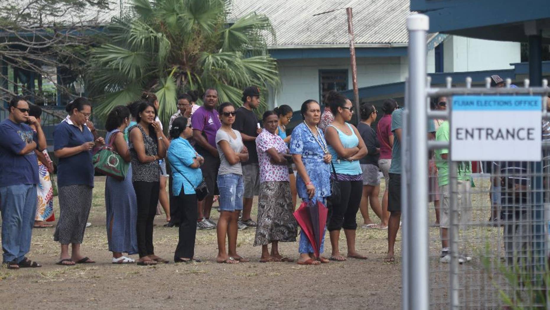 In this photo released by China's Xinhua News Agency, Fijian voters line up at a polling station in Suva, Fiji Wednesday, Sept. 17, 2014. Thousands of Fijians got their first chance to vote in eight years Wednesday in an election that promises to finally restore democracy to the South Pacific nation. (AP Photo/Xinhua, Michael Yang) NO SALES