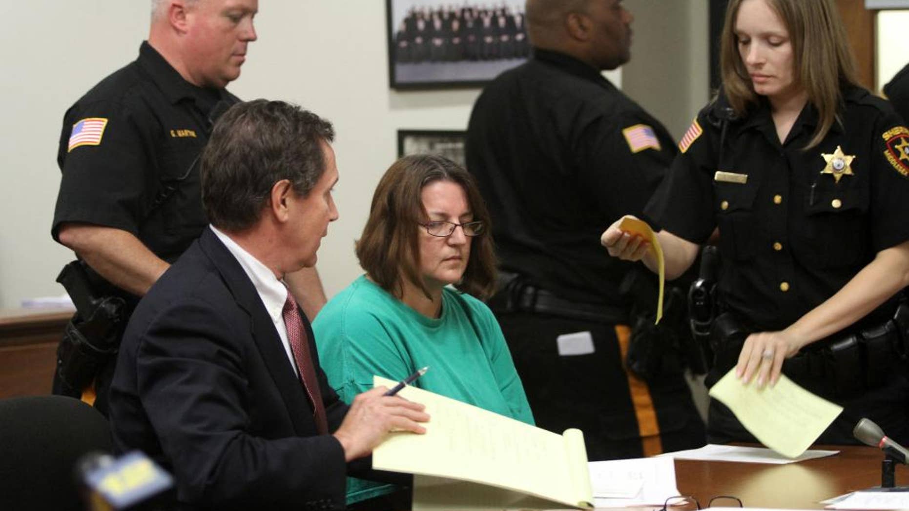 FILE - In this Sept. 16, 2014 file photo, Michelle Lodzinski, center, sits beside her attorney Gerald Krovatin during her arraignment in New Jersey Superior Court in New Brunswick, N.J. Lodzinski, a resident of Port St. Lucie, Fla., was convicted on Wednesday, May 18, 2016, of killing her 5-year-old son Timothy Wiltsey in New Jersey in May 1991. (Jason Towlen/Home News Tribune via AP, Pool, File)