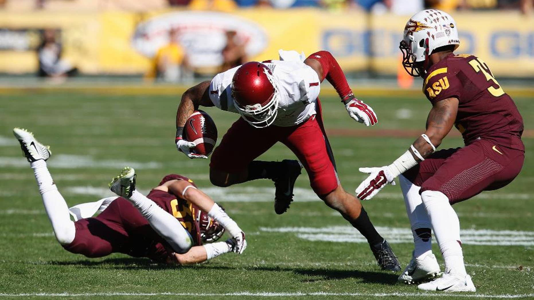 Washington State's Vince Mayle (1) slips past Arizona State's Jordan Simone, left, as Arizona State's Antonio Longino (32) moves in to make the tackle during the first half of an NCAA college football game Saturday, Nov. 22, 2014, in Tempe, Ariz. (AP Photo/Ross D. Franklin)