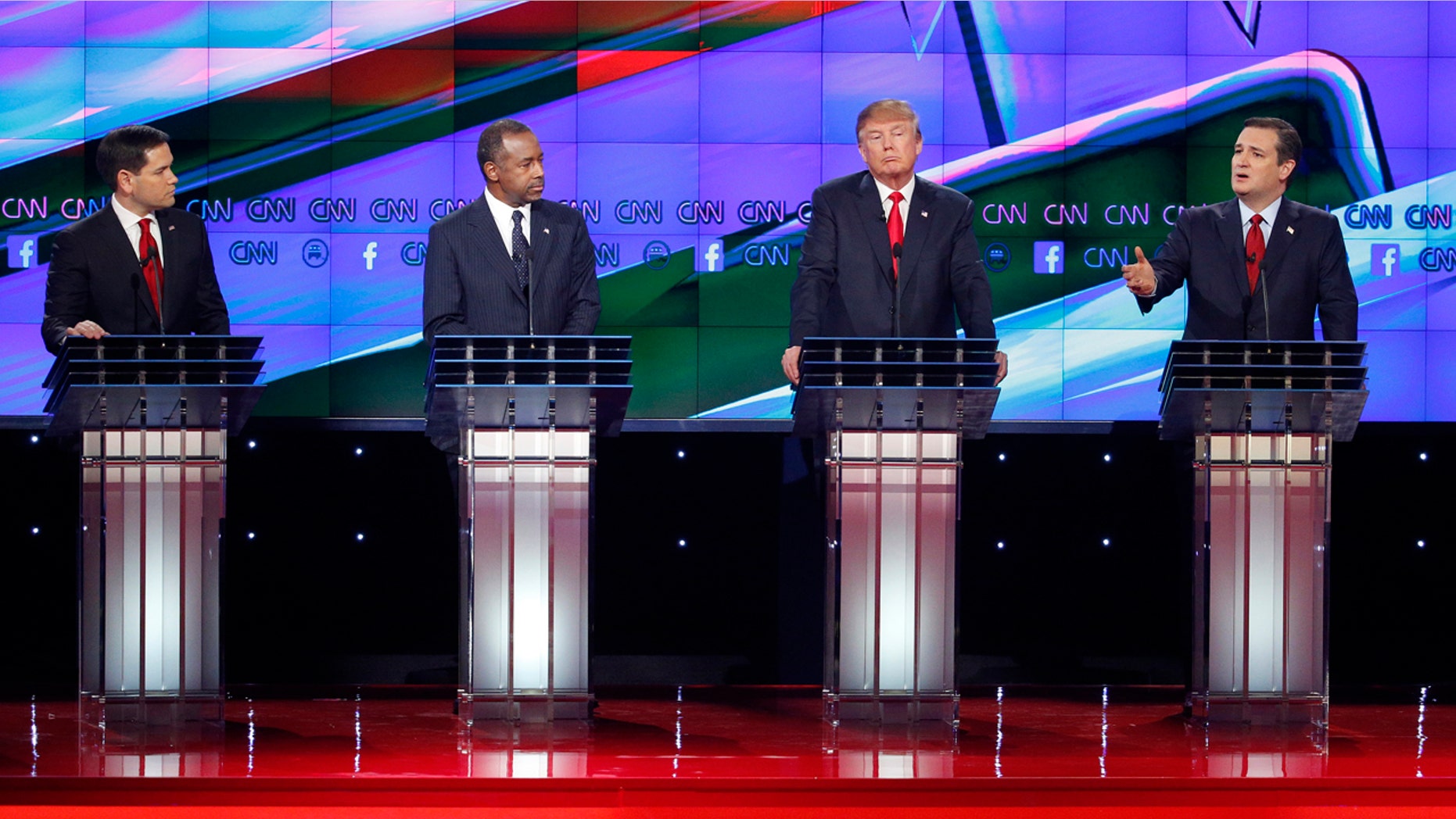 Ted Cruz, right, speaks during an exchange with Marco Rubio, left, as Ben Carson, second from left, and Donald Trump look on during the CNN Republican presidential debate at the Venetian Hotel & Casino on Tuesday, Dec. 15, 2015, in Las Vegas. (AP Photo/John Locher)