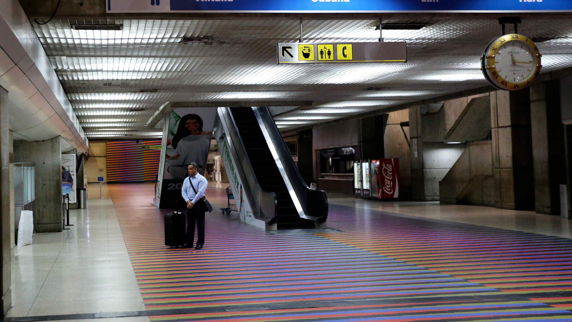 A passenger stands next to Air France desk at Simon Bolivar International Airport in Maiquetia near Caracas, Venezuela, Saturday, Dec. 14, 2013. Venezuelan bomb experts are inspecting a grounded Air France flight after being tipped off by French authorities that a terrorist group may be planning to detonate an explosive device in midair. Venezuelan Interior Minister Miguel Rodriguez Torres told state TV that a team of more than 60 technicians are performing an exhaustive search of the aircraft that will take several hours before the flight can be reprogrammed.(AP Photo/Fernando Llano)