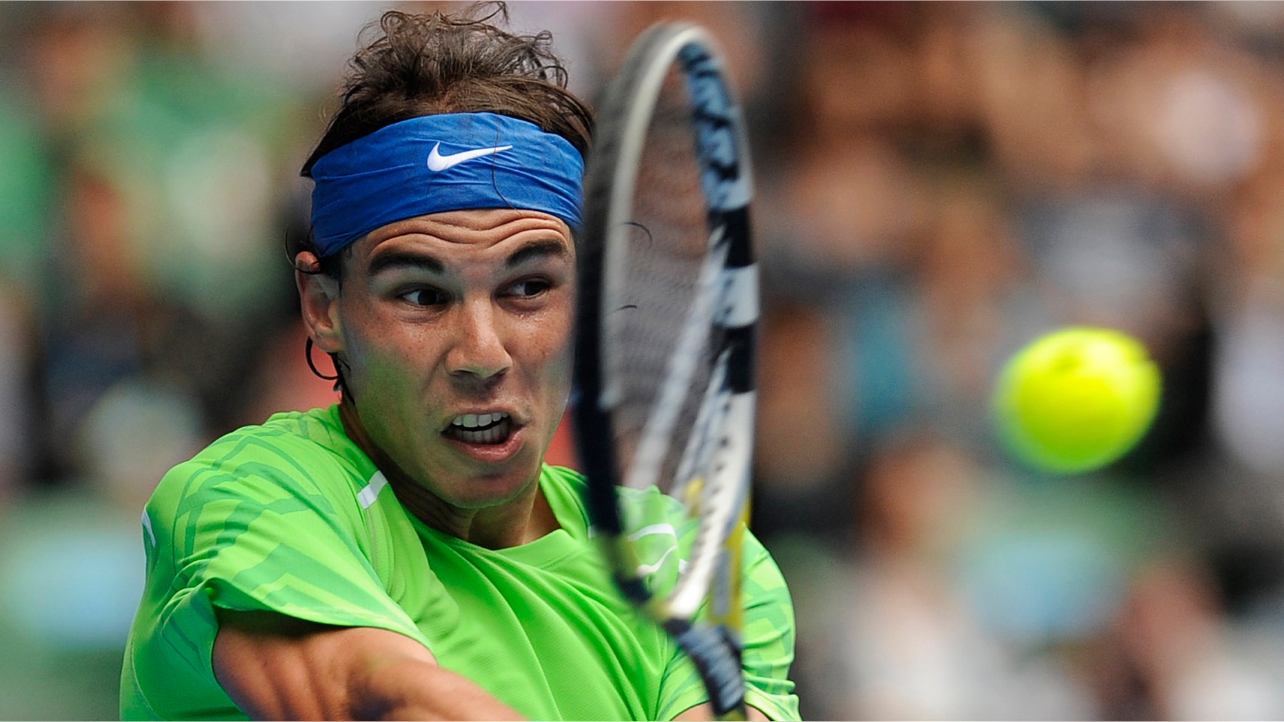 Spain's Rafael Nadal makes a backhand return to Slovakia's Lukas Lacko during their third round match at the Australian Open tennis championship, in Melbourne, Australia, Friday, Jan. 20, 2012. (AP Photo/Andrew Brownbill)