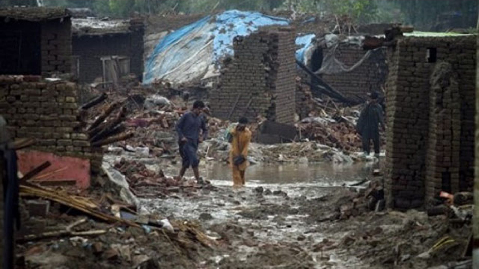 Aug. 8: Flood effected people walk past the rubble the collapsed houses in Azakhel near Nowshera, Pakistan. The country will need billions of dollars to recover from its worst floods in history, further straining a country already dependent on foreign aid to prop up its economy and back its war against Islamist militants, the U.N. said (AP).