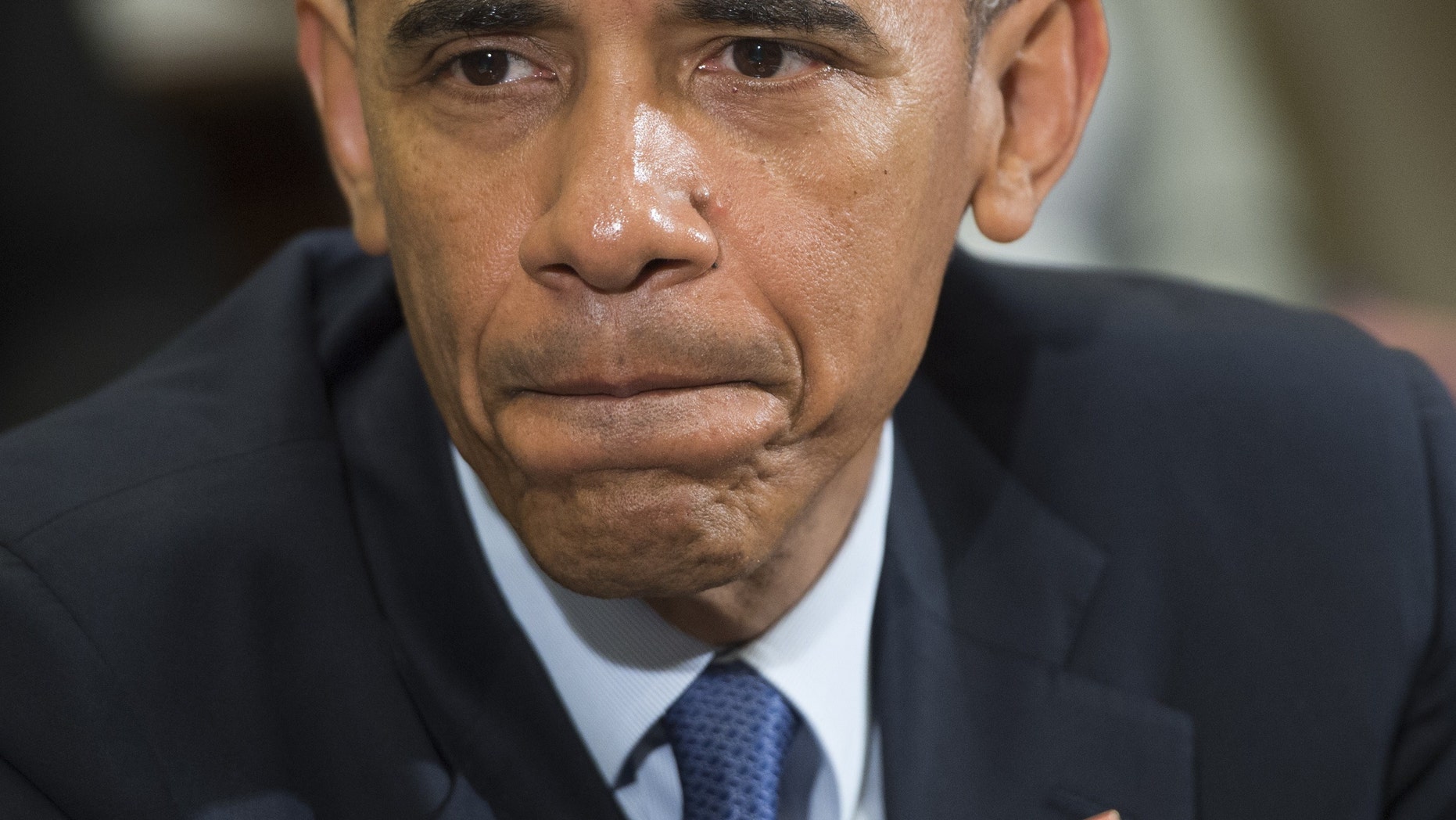 US President Barack Obama speaks about the report of a video released by the Islamic State depicting the killing of a Jordanian fighter pilot, during an unrelated meeting with Americans who say they have benefited from the Affordable Care Act, commonly known as "Obamacare," in the Roosevelt Room of the White House in Washington, DC, February 3, 2015. (Photo credit should read SAUL LOEB/AFP/Getty Images)