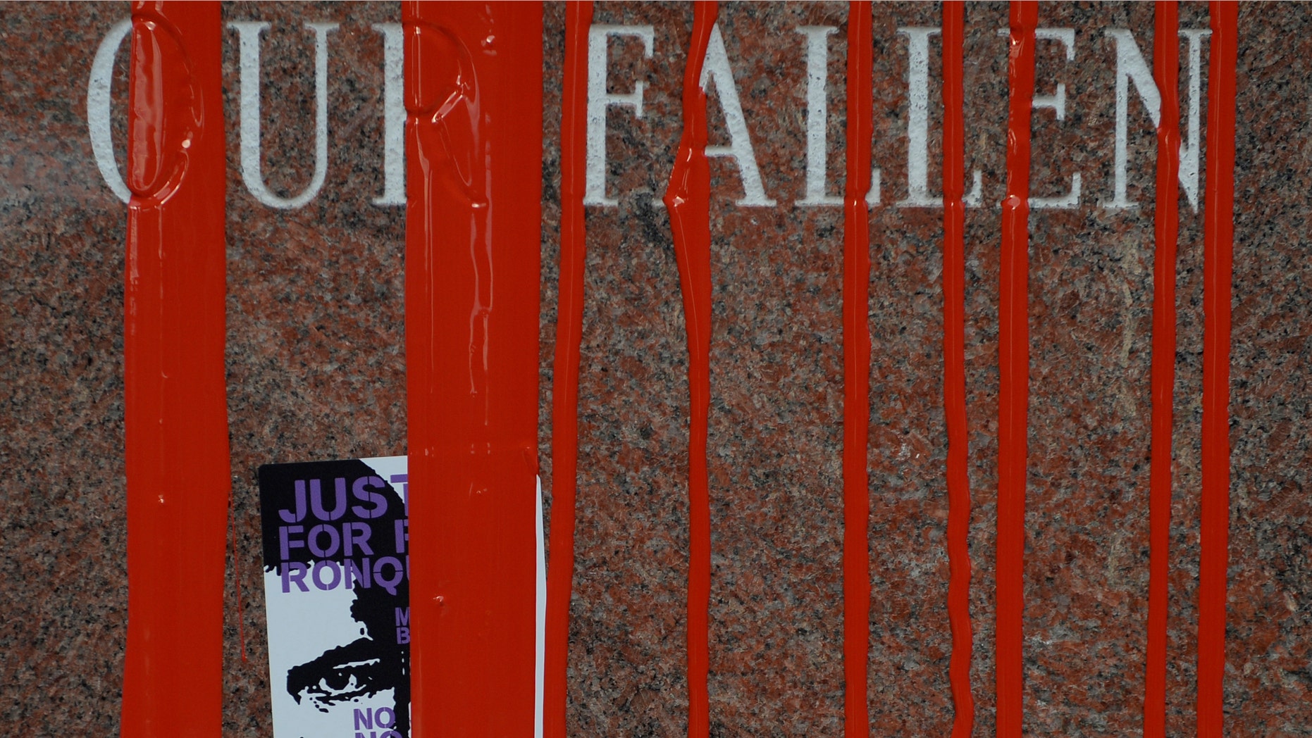 Stickers and red paint cover the fallen police memorial February 14, 2015 at the Denver Police Administration Building.
