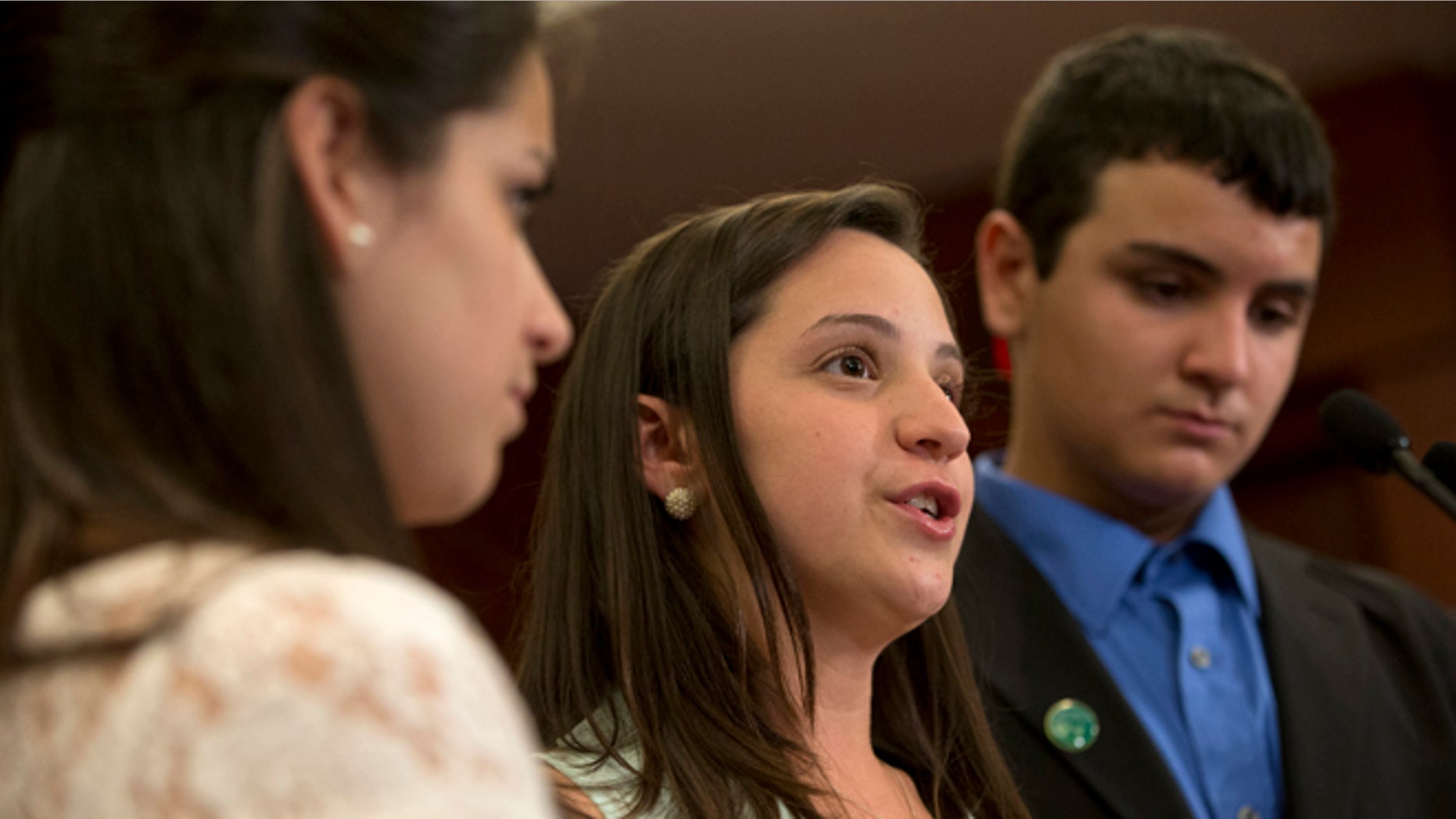 FILE - In a Thursday, June 13, 2013 file photo, Jillian Soto, center, with sister Carlee Soto, left and brother Carlos Soto, the siblings of Victoria Soto, speaks during a news conference on Capitol Hill in Washington, on the sixth month anniversary of the Newtown, Conn. shootings. The family of Victoria Soto, who was killed in the Sandy Hook school massacre, has applied to trademark her name in an attempt to stop others from misusing it on social media. (AP Photo/Jacquelyn Martin, File)