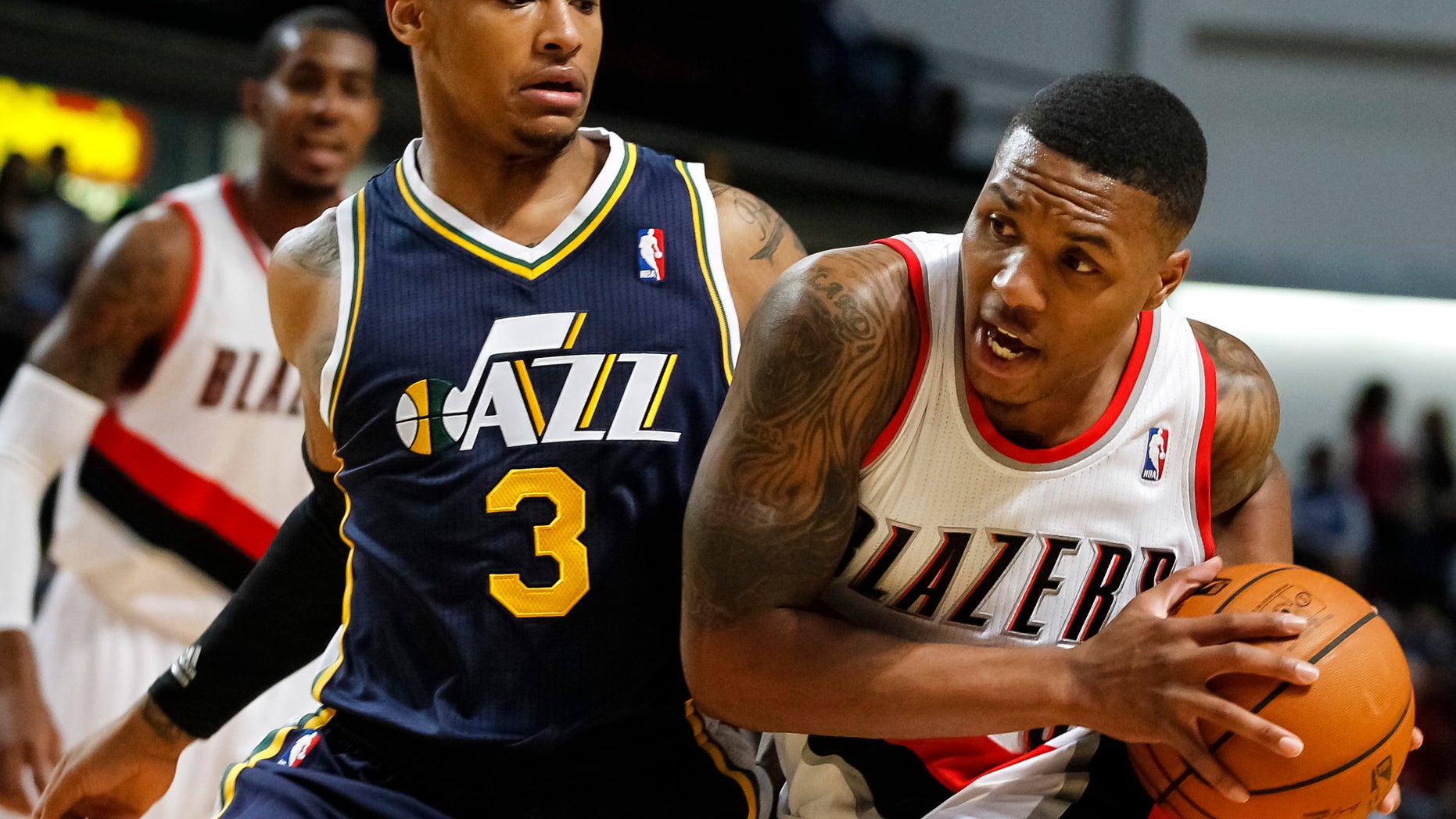 Portland Trail Blazers point guard Damian Lillard, right, drives the ball past Utah Jazz point guard Trey Burke (3) in the first half of a preseason NBA basketball game on Friday, Oct. 11, 2013, in Boise, Idaho. (AP Photo/Otto Kitsinger)