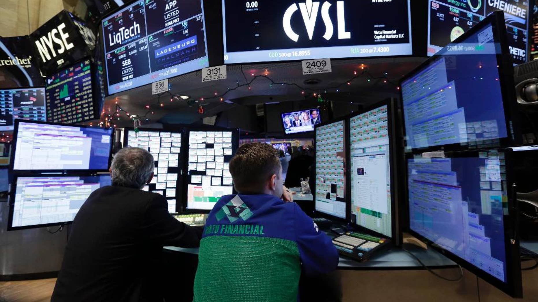 A pair of specialists work on the floor of the New York Stock Exchange, Friday, Dec. 5, 2014. The main focus in the markets Friday was the monthly U.S. jobs survey from the Labor Department, which showed U.S. employers added 321,000 jobs last month, the biggest burst of hiring in nearly three years. (AP Photo/Richard Drew)