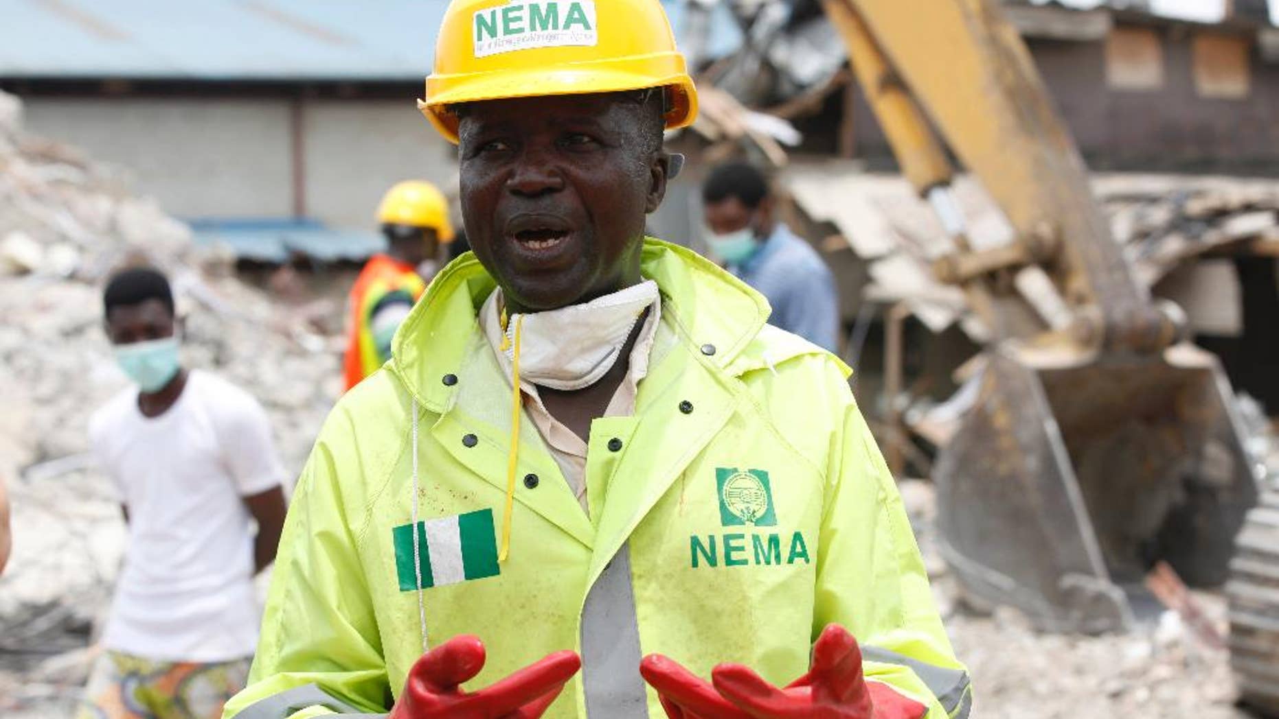 FILE- In this Wednesday, Sept. 17, 2014 file photo, Ibrahim Farinloye, spokesman for the Nigerian Emergency Management Agency, speaks on the rubble of a collapsed building belonging to the Synagogue Church of All Nations in Lagos, Nigeria. Lives were lost as church officials prevented workers from rescuing victims at the scene of a collapsed building in Lagos, Nigeria’s emergency agency said Friday, Sept. 19, 2014. Most victims were South African, according to the South African government, which said at least 67 South Africans died and 17 appear missing in the rubble of the six-story building that had a shopping mall on the ground floor and guest rooms above. (AP Photo/Sunday Alamba, File)