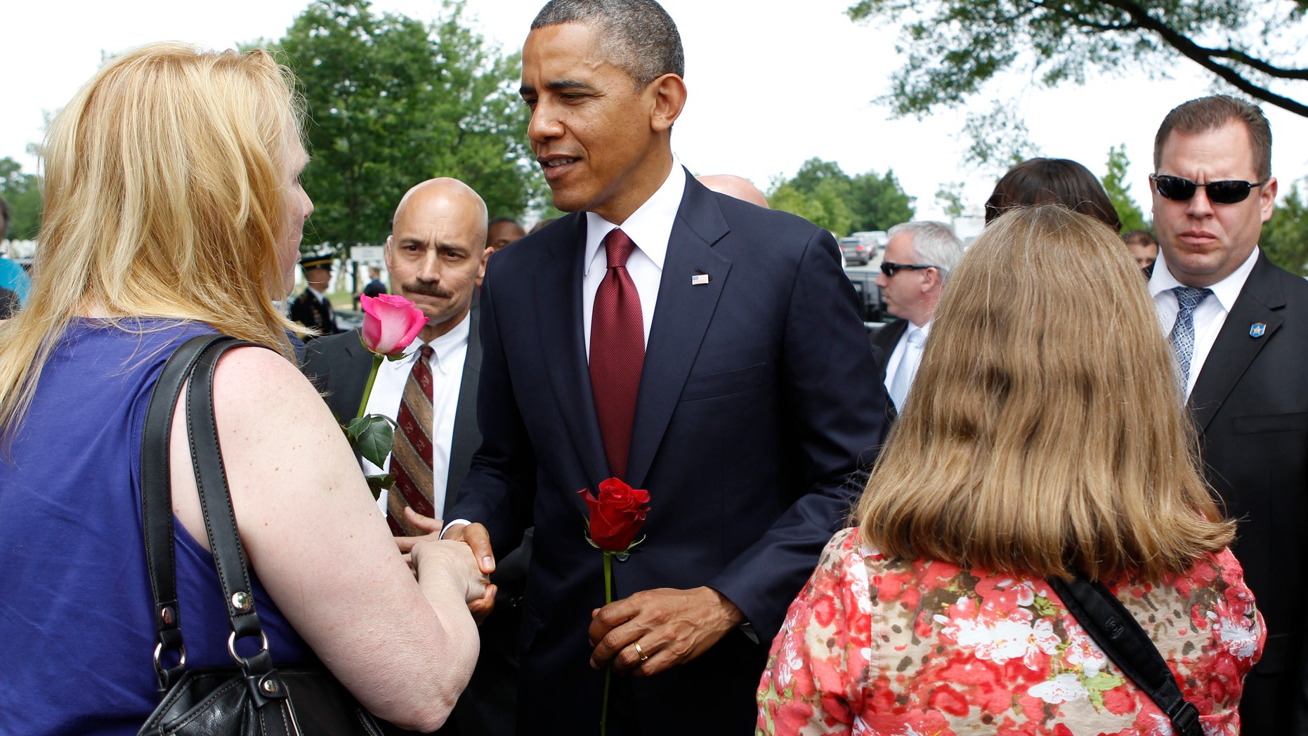 President Barack Obama greets visitors of Section 60 at Arlington National Cemetery on Memorial Day in Arlington, Va., Monday, May 27, 2013. Iraq and Afghanistan war veterans are buried in Section 60. (AP Photo/Molly Riley)