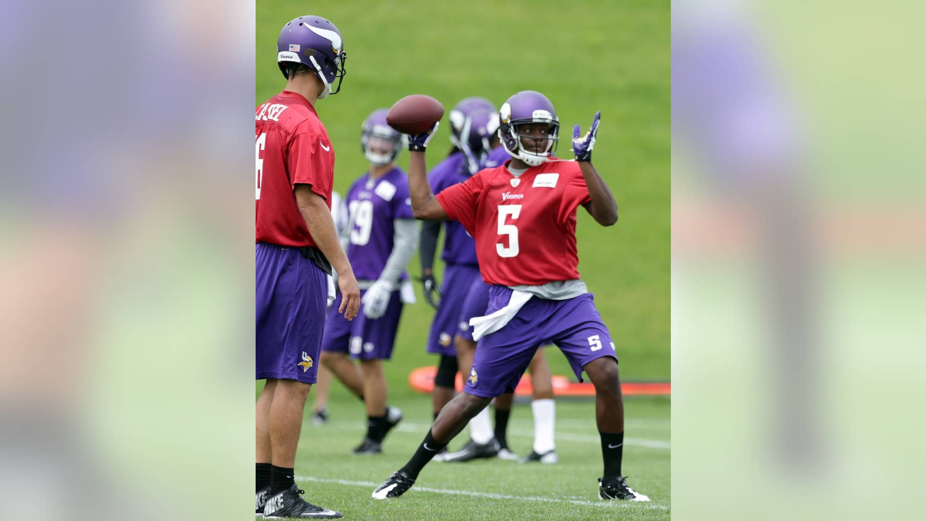 Minnesota Vikings quarterback Matt Cassel, left, watches as rookie quarterback Teddy Bridgewater throws during NFL football minicamp Wednesday, June 18, 2014, in Eden Prairie, Minn. (AP Photo/Jim Mone)