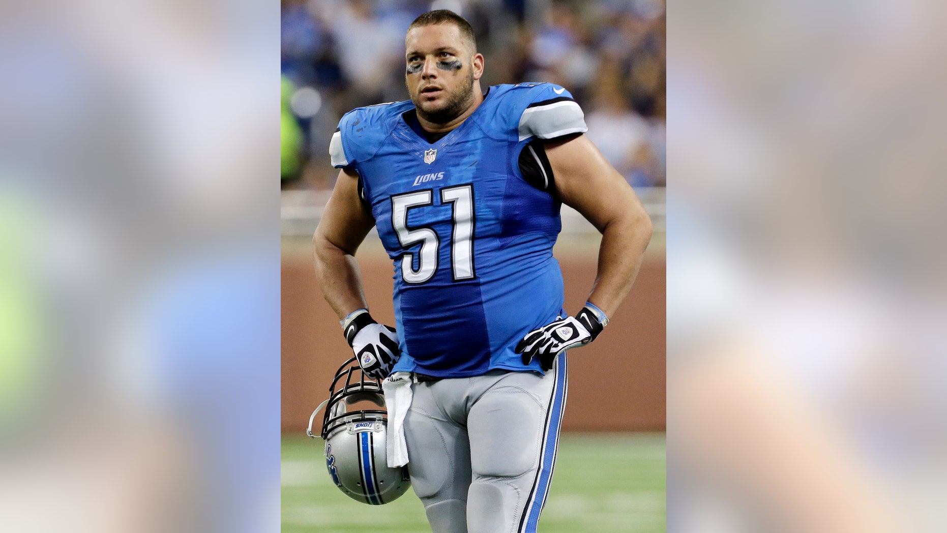 FILE - In this Sept. 8, 2013, file photo, Detroit Lions center Dominic Raiola watches during the third quarter of an NFL football game against the Minnesota Vikings at Ford Field in Detroit. Raiola apologized Tuesday, Oct. 8, 2013, for "unacceptable" remarks he made to the University of Wisconsin band over the weekend as his team moved swiftly to defuse an off-the-field distraction. Band members said Raiola verbally abused them at Lambeau Field, where they were performing before and after Sunday's Lions-Packers game. (AP Photo/Paul Sancya)