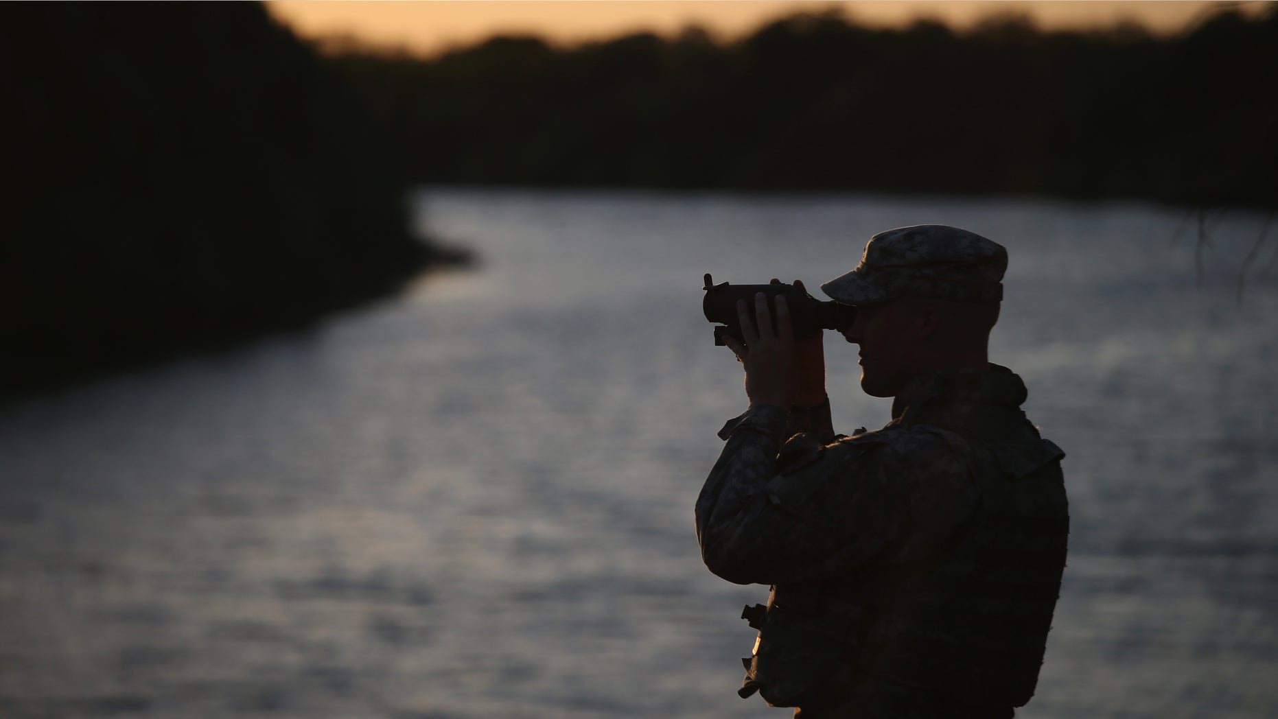 HAVANA, TX - SEPTEMBER 11: A Texas National Guard soldier scans the Mexican side of the U.S.-Mexico border on September 11, 2014 in Havana, Texas. The troops, deployed along the Rio Grande, are part of a 1,000 strong force called up by Texas Governor Rick Perry to guard the border. The soldiers were sent to help state and federal law enforcement stem a surge of illegal immigrants, many of them families and unaccompanied minors. (Photo by John Moore/Getty Images)