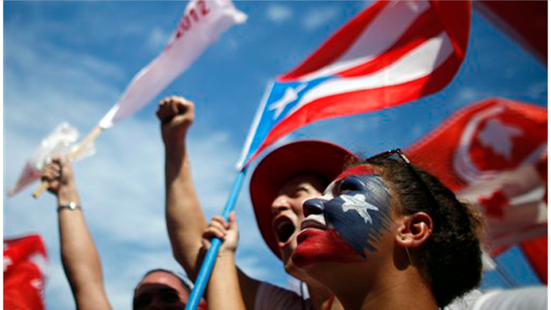 Supporters of Alejandro Garcia Padilla, candidate for governor of the pro-commonwealth Popular Democratic Party, cheer during his closing campaign rally in San Juan, Puerto Rico, Sunday, Nov. 4, 2012. Puerto Rican voters will once again ponder the decades-old question over the island's political future when they go to the polls Tuesday: What kind of relationship do they really want with the United States? Officially, the Caribbean island is the U.S. Commonwealth of Puerto Rico, a semi-autonomous extension of the U.S. mainland, its giant neighbor 1,000 miles to the northwest. (AP Photo/Ricardo Arduengo)