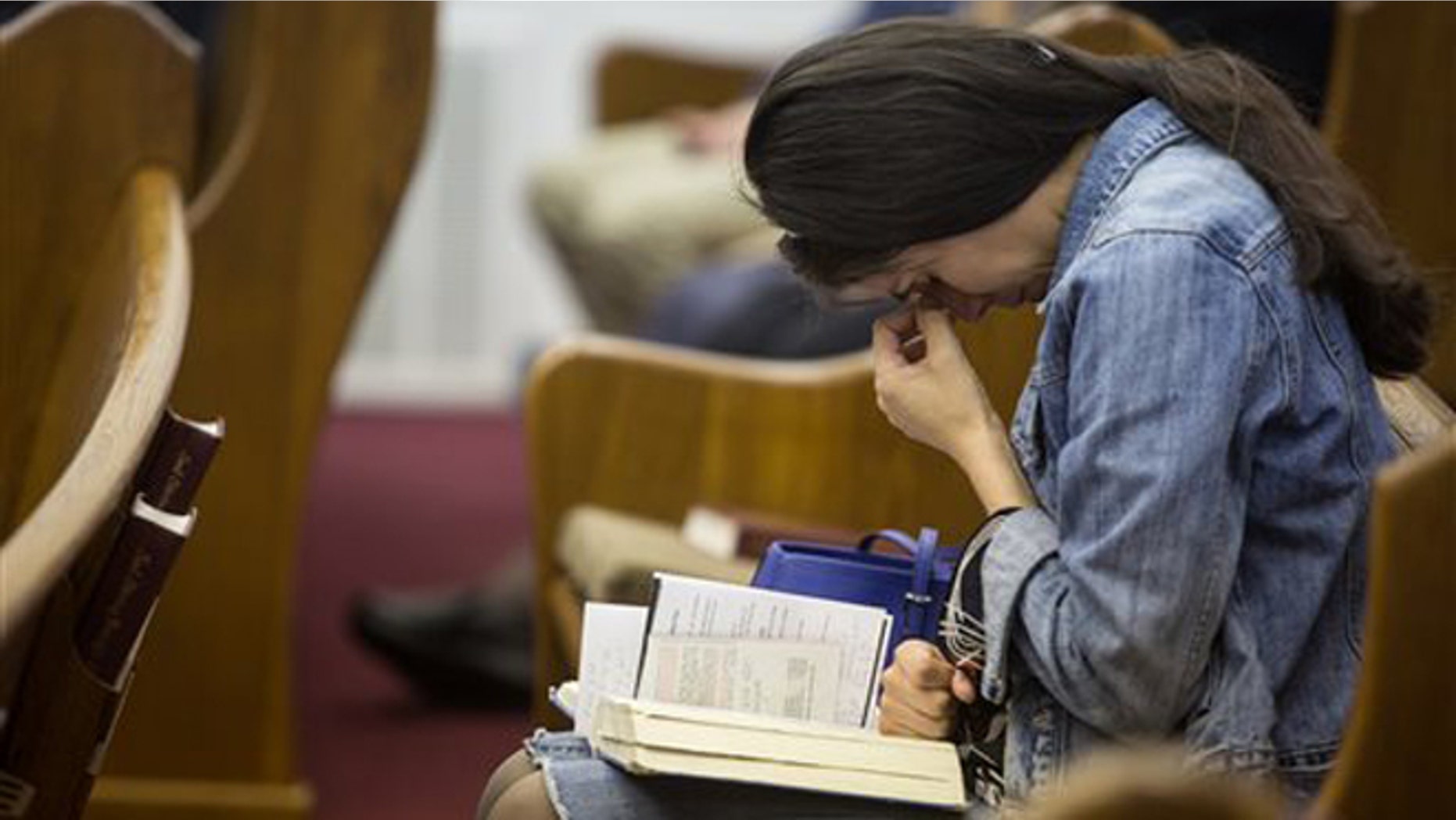 April 6, 2014: Kathy Abad, a military wife, prays for the victims and families affected by the Fort Hood shooting during a memorial service at the Tabernacle Baptist Church.