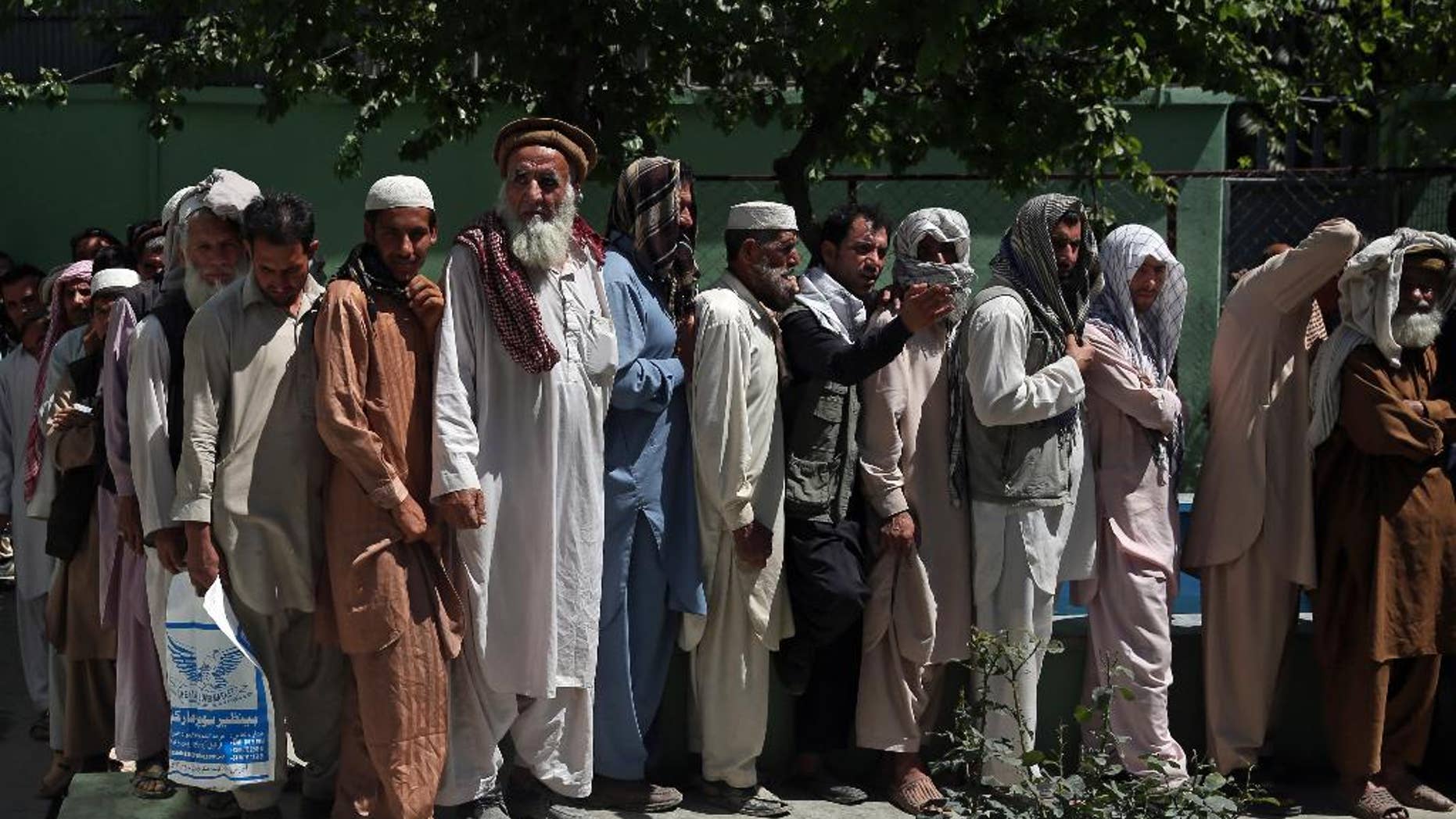 Afghan men wait in line to receive food donation during the holy month of Ramadan in Kabul, Afghanistan, Thursday, June 25, 2015. Muslims throughout the world are marking the month of Ramadan, the holiest month in the Islamic calendar during which devotees fast from dawn till dusk. (AP Photo/Massoud Hossaini)