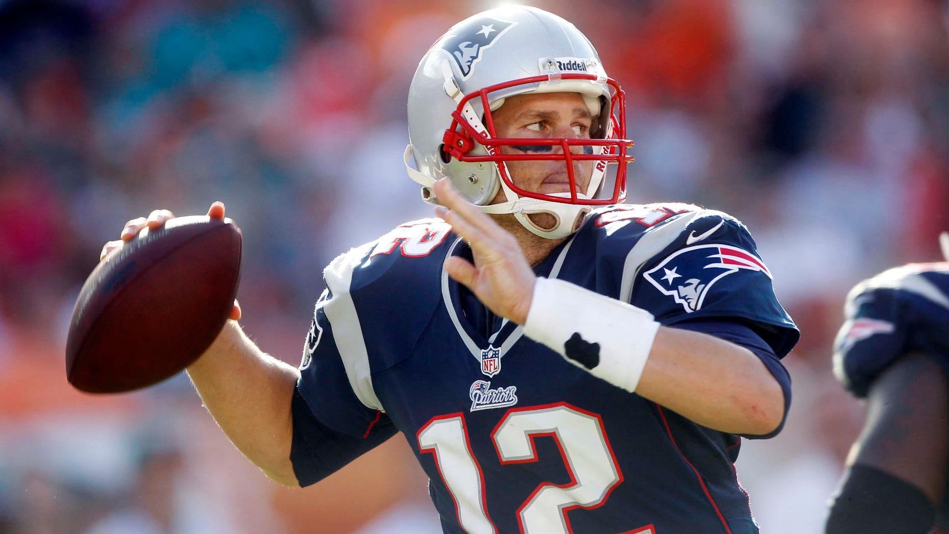 FILE - In this Dec. 2, 2012, file photo, New England Patriots quarterback Tom Brady looks for a receiver during the second half of an NFL football game against the Miami Dolphins in Miami. Brady agreed to a three-year contract extension with New England on Monday, Feb. 25, 2013, a person familiar with the contract told The Associated Press. The extension is worth about $27 million and will free up nearly $15 million in salary cap room for the team. (AP Photo/John Bazemore, File)