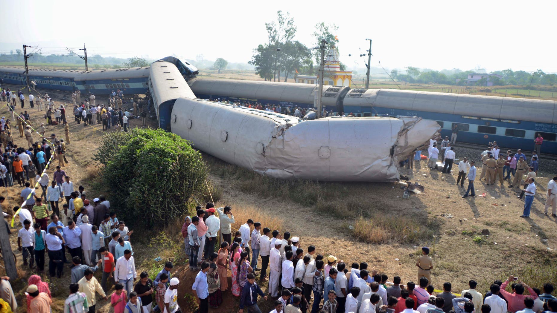 Indian people gather at the site of a train accident near Nashik, 165 kilometers (100 miles) north of Mumbai, India, Friday, Nov. 15, 2013. Police say the passenger train derailed in western India, killing at least two people and injuring another 25. The cause of the accident was not immediately known. (AP Photo)
