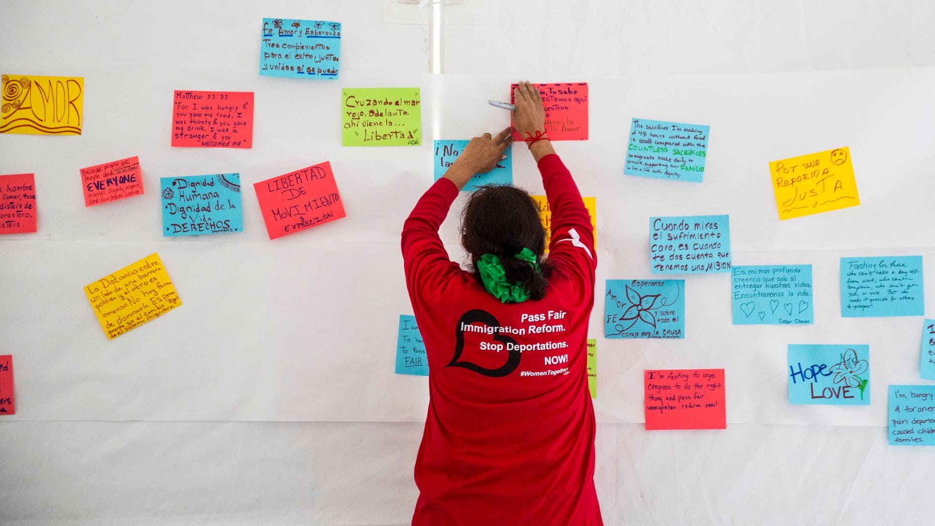 WASHINGTON, DC - APRIL 7:
Antonia Surco, of Silver Spring, Maryland, hangs hand-written messages about fasting for immigration reform on the wall of a tent on the National Mall, during the 'Women's Fast For Families' event, April 7, 2014 in Washington, DC. According to organizers, around 100 women signed up to fast for 48 hours on the National Mall to call for 'fair immigration reform and an end to deportations.' (Drew Angerer/Getty Images)