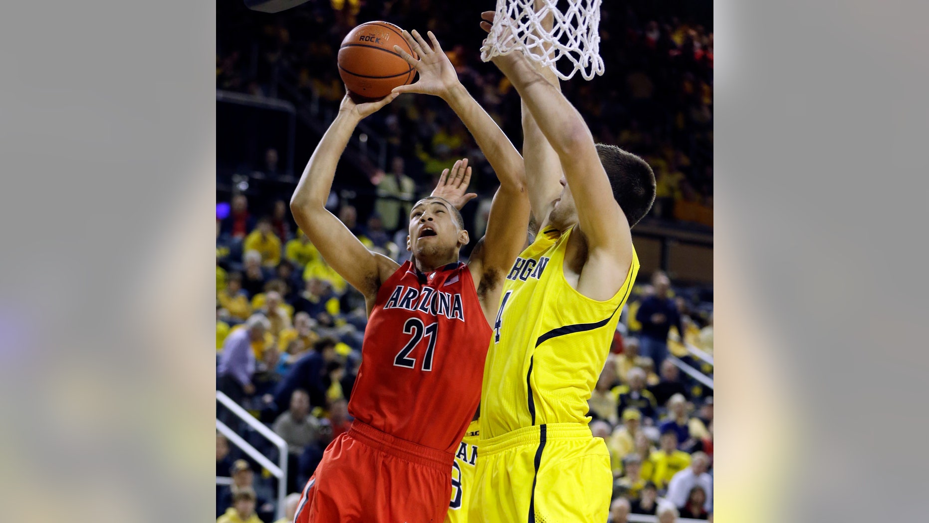 Arizona forward Brandon Ashley (21) makes a lay-up defended by Michigan forward Mitch McGary (4) during the second half of an NCAA college basketball game in Ann Arbor, Mich., Saturday, Dec. 14, 2013. (AP Photo/Carlos Osorio)