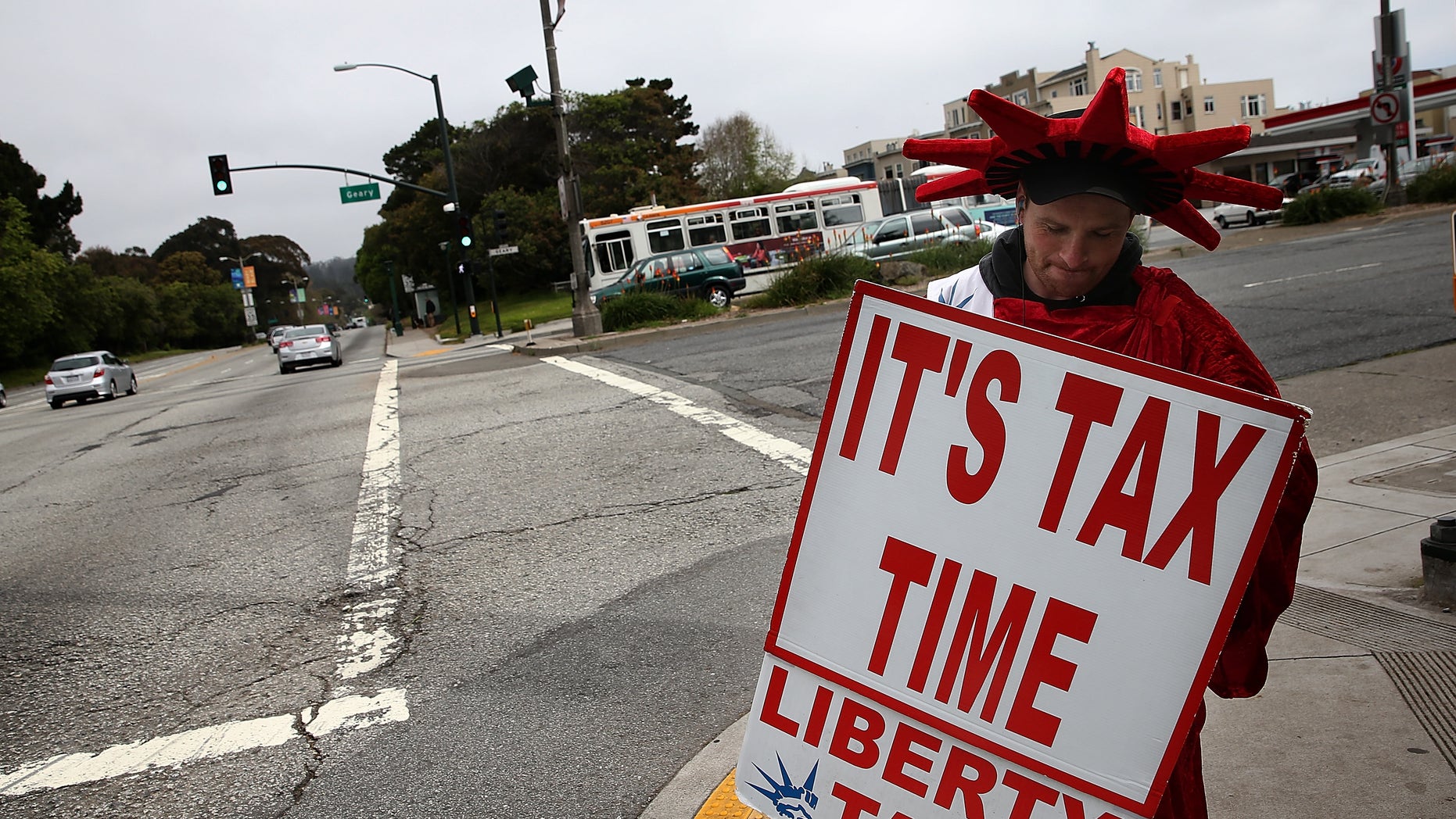 SAN FRANCISCO, CA - APRIL 14: Aaron Lee holds a sign advertising income tax services for Liberty Tax Service on April 14, 2014 in San Francisco, California. Tax preparers are helping last minute tax filers ahead of the April 15th deadline to file state and federal income taxes. The Internal Revenue Service is expecting an estimated 35 million returns in the week leading up to the deadline. (Photo by Justin Sullivan/Getty Images)