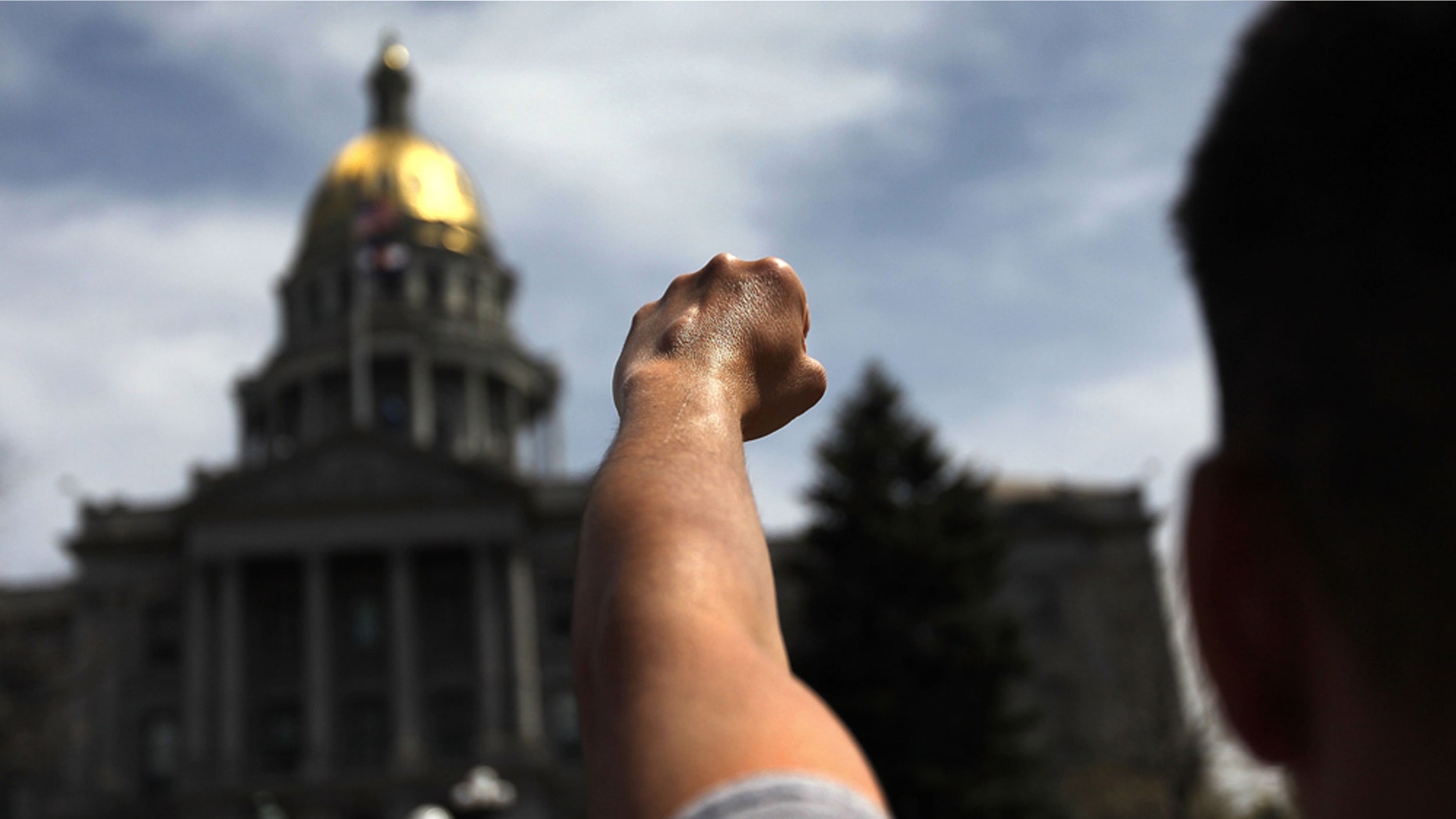 DENVER - APRIL 15: A protester demands immigration reform while demonstrating across the street from a "Tax Day Tea Party" event at the state capitol building on April 15, 2010 in Denver, Colorado. Tea Party groups held anti-government protests nationwide on the day when Americans must file their annual income tax returns. (Photo by John Moore/Getty Images)