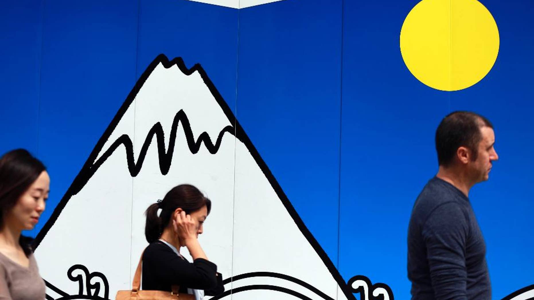 In this June 8, 2016 photo, people walk past a wall drawing depicting Mount Fuji at Ginza shopping district in Tokyo. Japan's economy expanded at a better-than-estimated 0.7 percent annualized pace in April-June, according to revised data showing private demand was stronger than earlier reported. (AP Photo/Eugene Hoshiko)