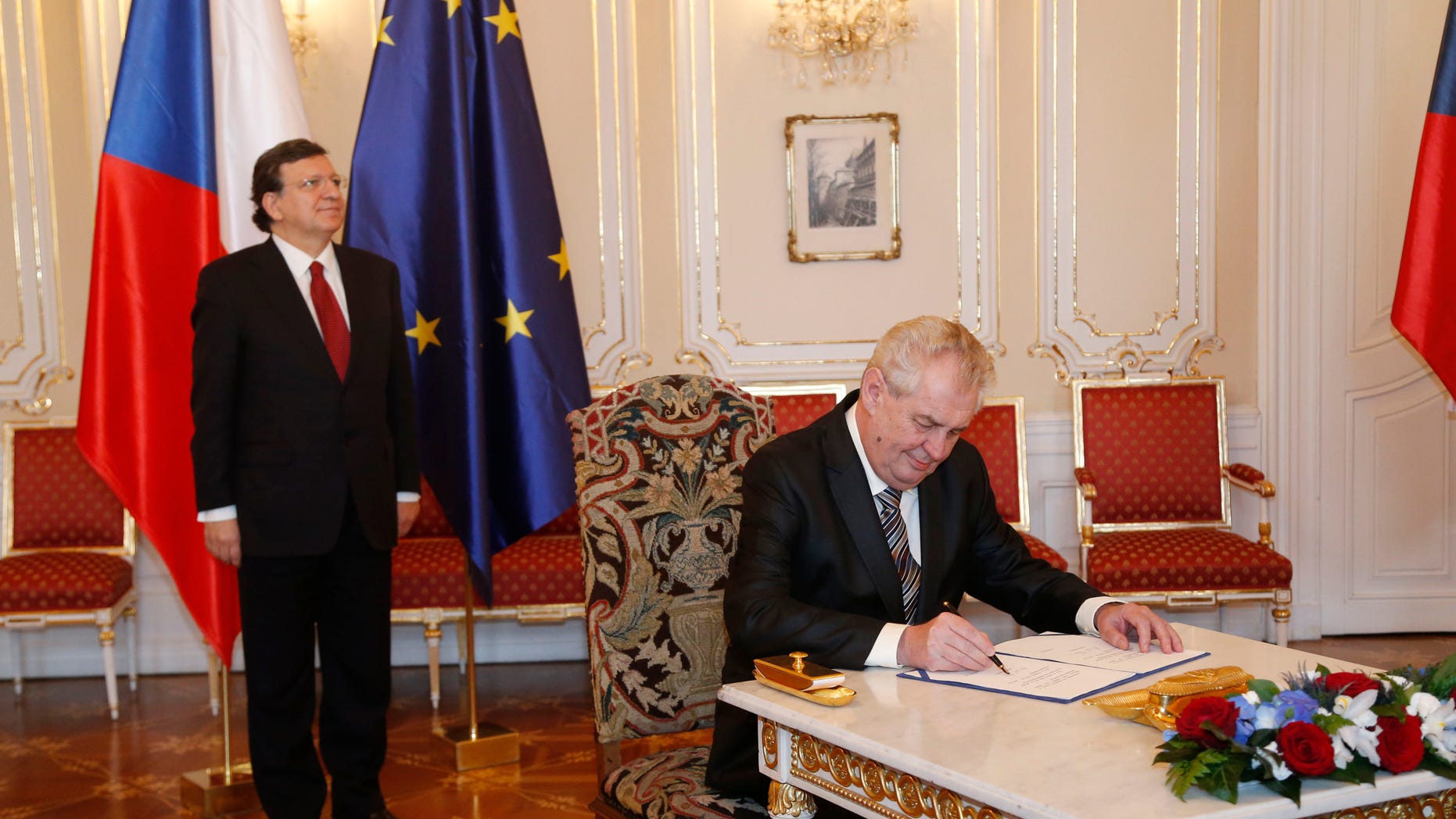 European Commission President Jose Manuel Barroso, left, looks on as Czech Republic's President Milos Zeman, right, signs the European Union bailout fund at the Prague Castle in Prague, Czech Republic, Wednesday, April 3, 2013. (AP Photo/Petr David Josek)