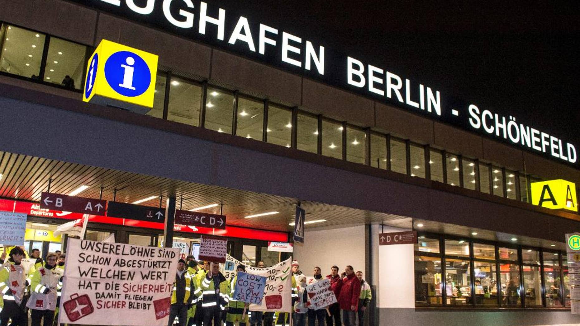 FILE - In this Feb. 8, 2017 file photo, members of the airport ground staff stand at Schoenefeld airport in Berlin, during a warning strike. A union representing ground staff has called on its members to go on strike at Berlin's two airports and warned the walkouts might lead to delays and perhaps flight cancellations. The ver.di union says the strikes would begin Friday at 4 a.m. (0300 GMT) and end Saturday at 5 a.m. (0400 GMT) at the German capital's Tegel and Schoenefeld airports. (Paul Zinken/dpa via AP)